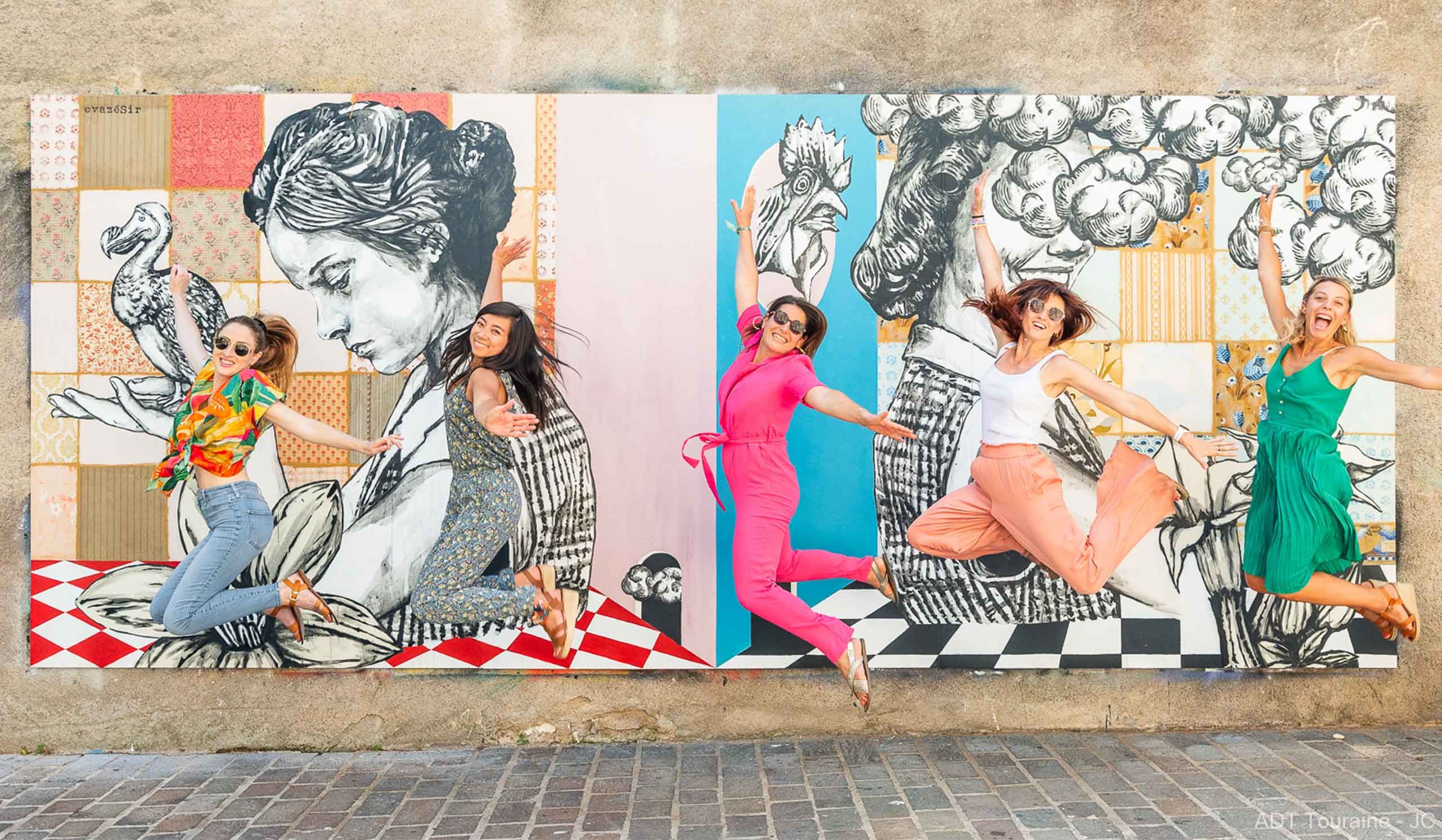 Cinq jeunes femmes sautant devant le graff du MUR de Tours