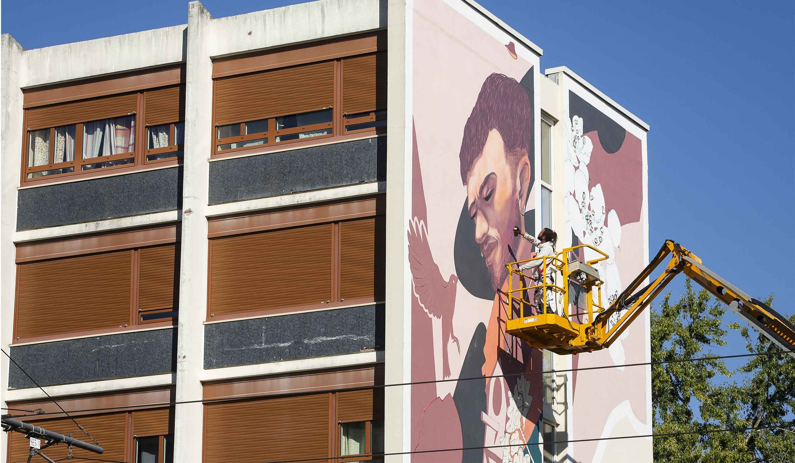 Graffeur entrain de créer une oeuvre sur un pan d'immeuble dans le quartier du Sanitas à Tours
