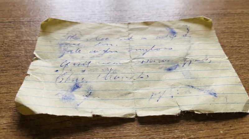 A close view of an old handwritten note on lined paper, ink faded with age