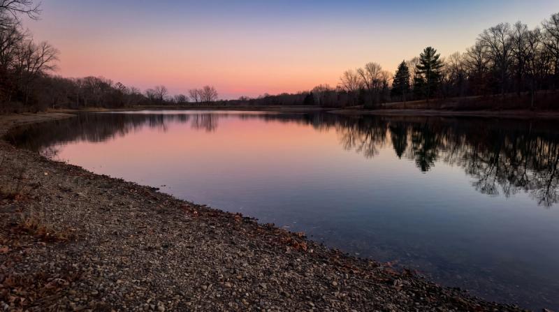A quiet reservoir at dusk with the reflection of the sky on the water