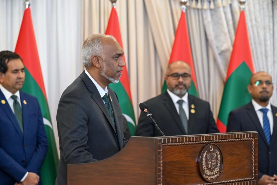 President Muizzu, seen in profile, speaks at the lectern.