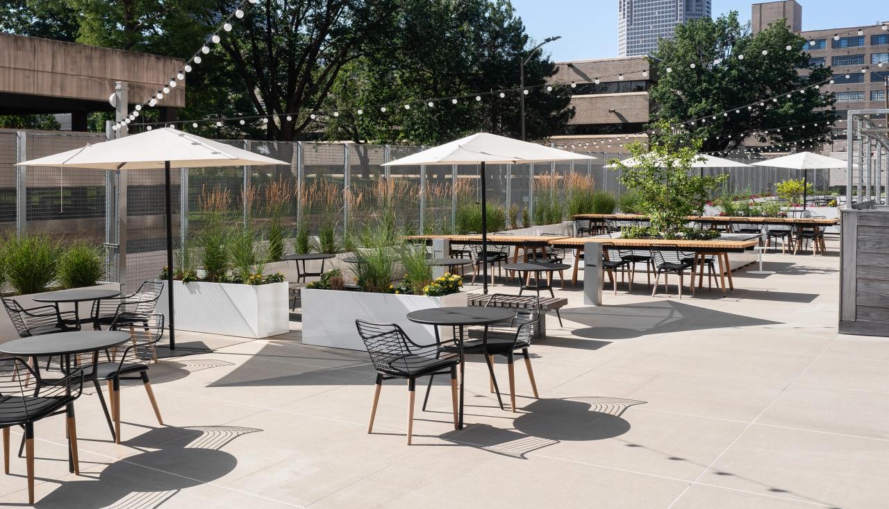 Empty tables and chairs at the stl post dispatch building amenity courtyard designed by arbolope studio.