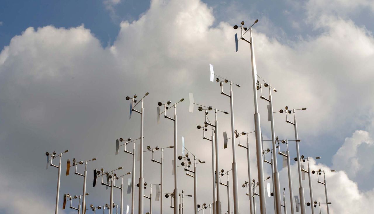 Anemometers high in the sky against white clouds, reading wind speeds on washington university campus in st louis missouri