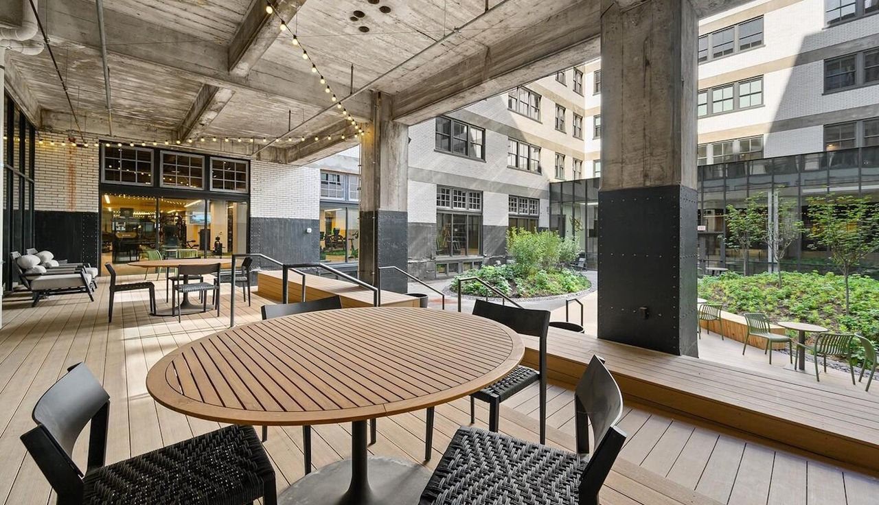 Overlooking the courtyard, the amenity deck offers a versatile space for relaxation and gatherings. The covered area, complete with seating and tables, provides residents with a seamless connection to the outdoor landscape.
