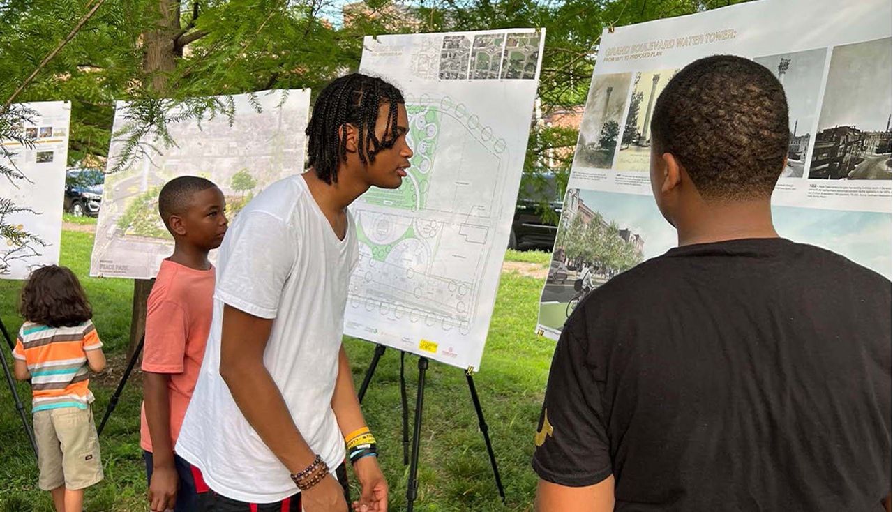 Photo of Students reading posters explaining the vacant lots toolkit in st louis missouri schools by arbolope studio.
