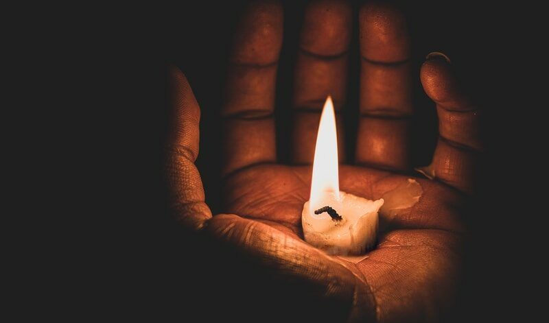 lit candle in hand