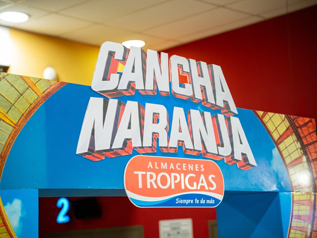 Arco de entrada de la activación Cancha Naranja, con el logo de Almacenes Tropigas.