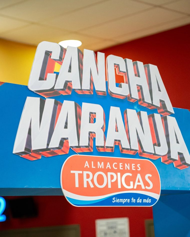 Arco de entrada de la activación Cancha Naranja, con el logo de Almacenes Tropigas.