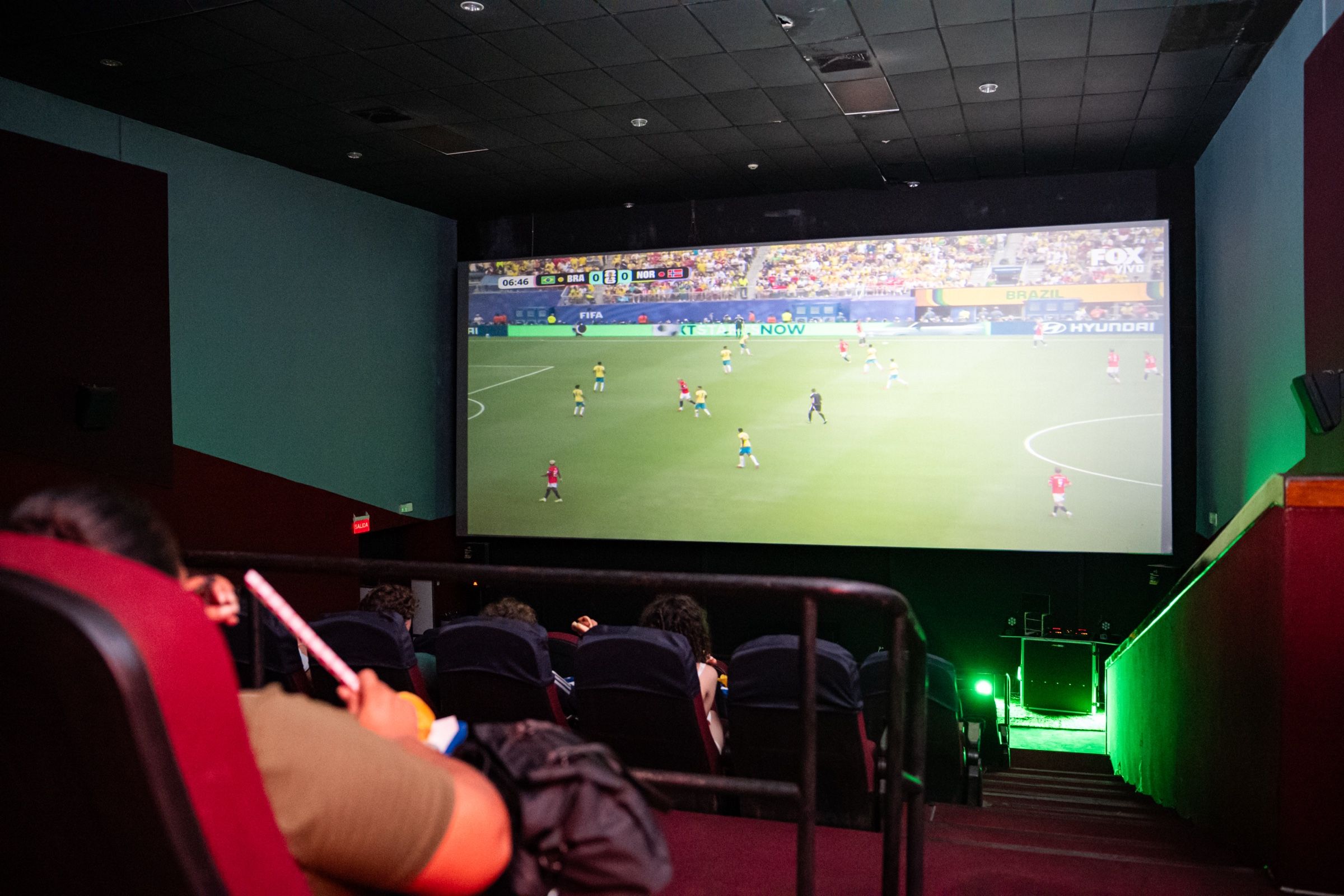 La sala durante el partido, con el juego proyectado en la pantalla grande.