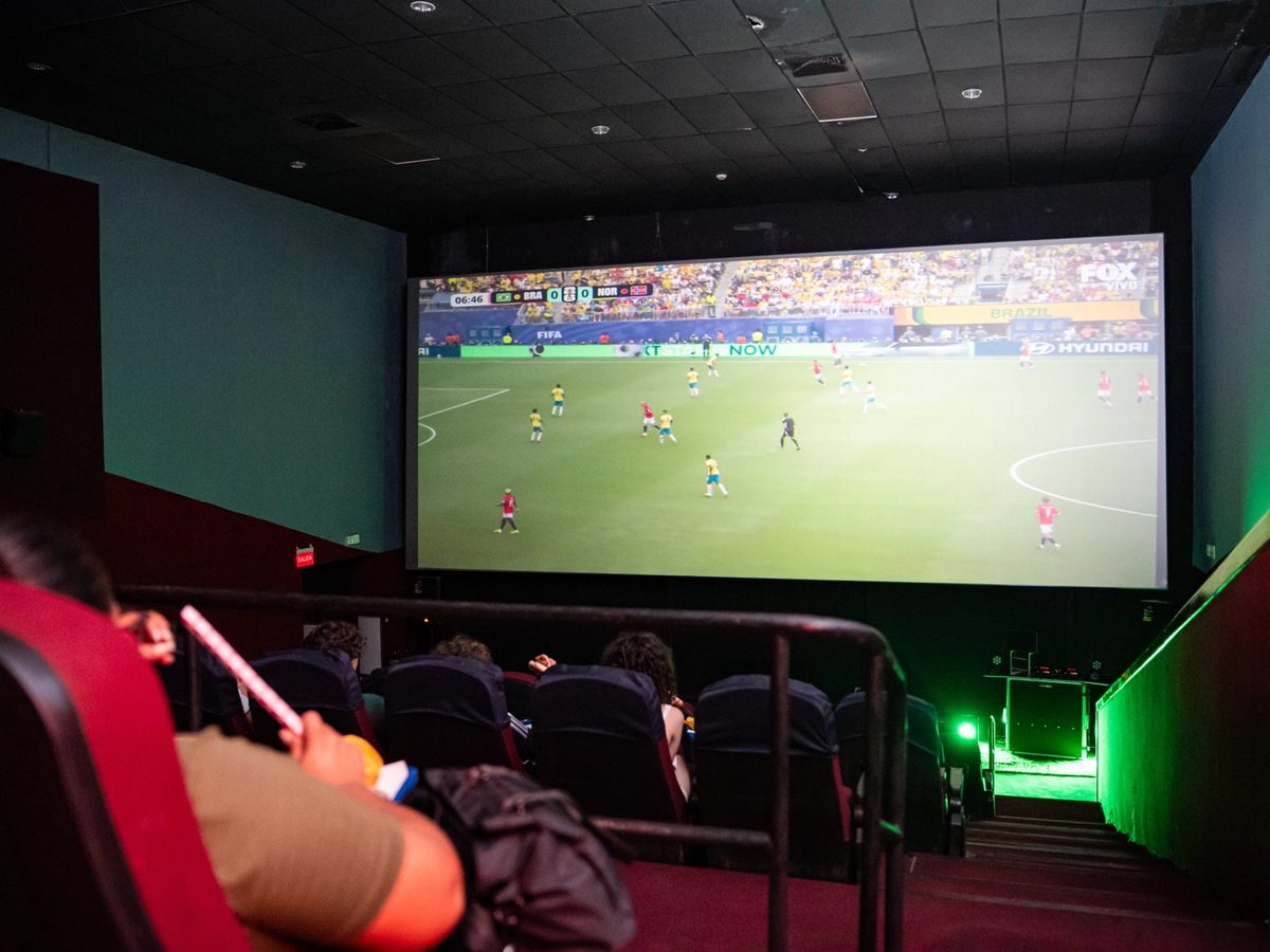 La sala durante el partido, con el juego proyectado en la pantalla grande.