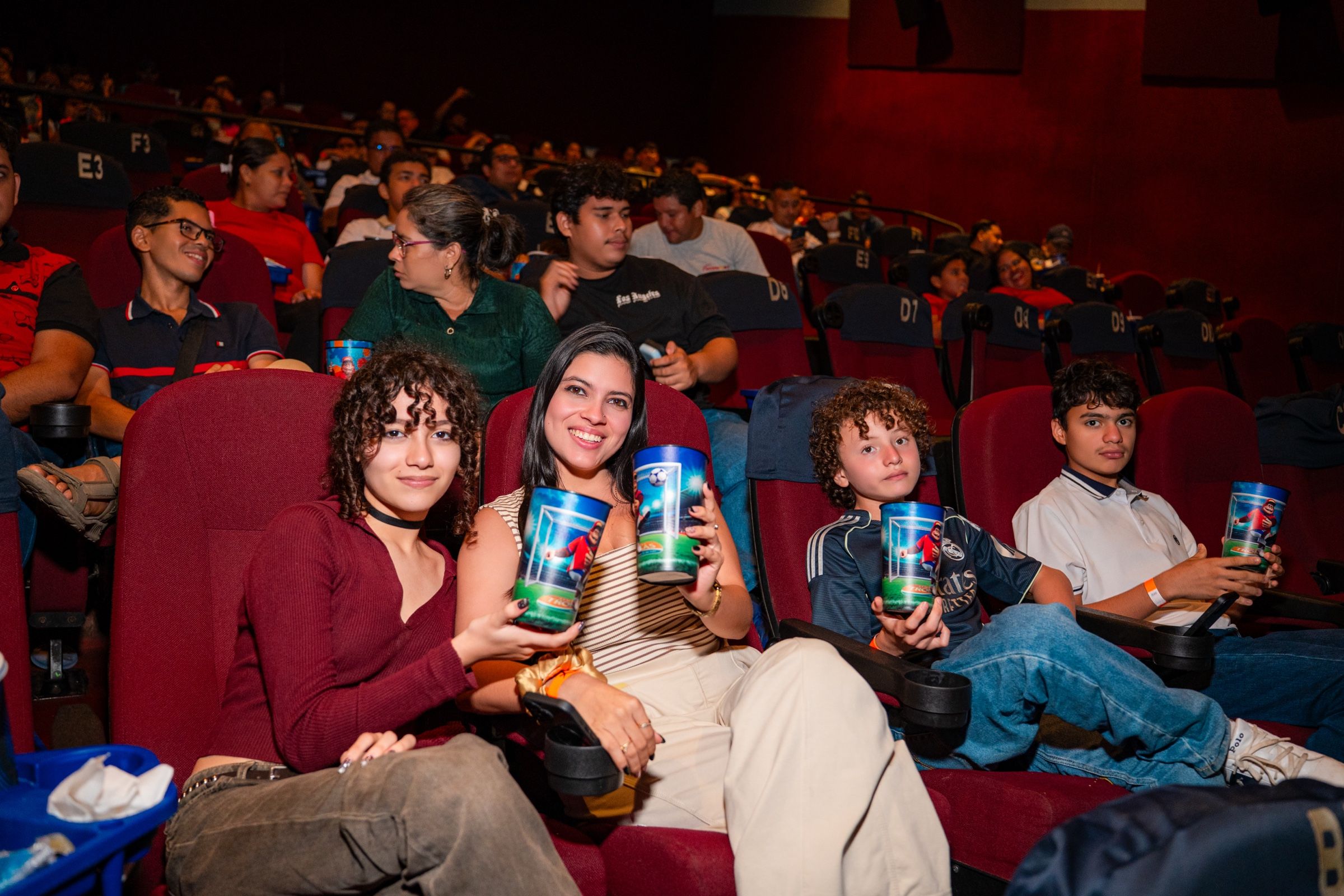 Público en la sala durante la función, con los vasos de Cancha Naranja.
