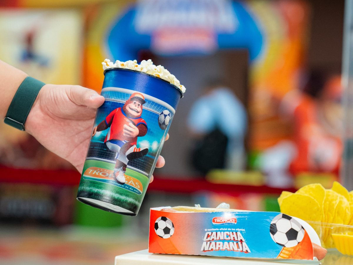 Vaso y caja de combo de Cancha Naranja sobre el mostrador de la dulcería.