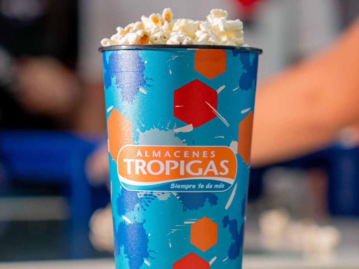 Vaso de palomitas de Cancha Naranja sobre el mostrador de la dulcería.