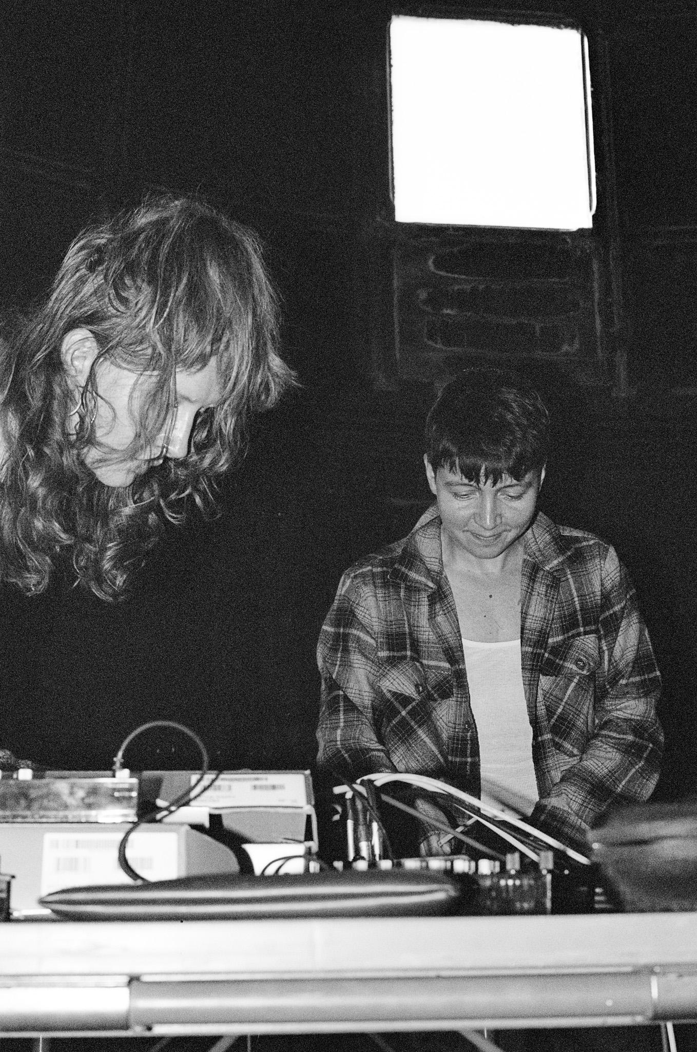 2 people stood over dj decks