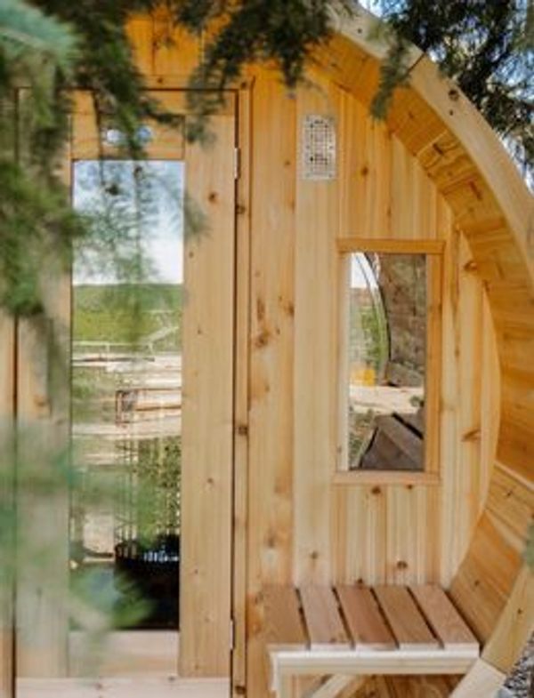 Cedar barrel sauna detail framed by pine branches