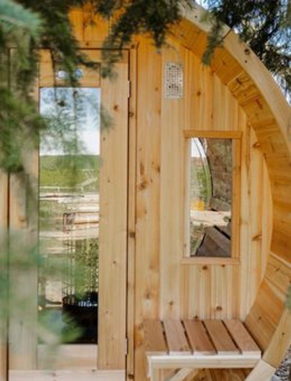 Cedar barrel sauna detail framed by pine branches