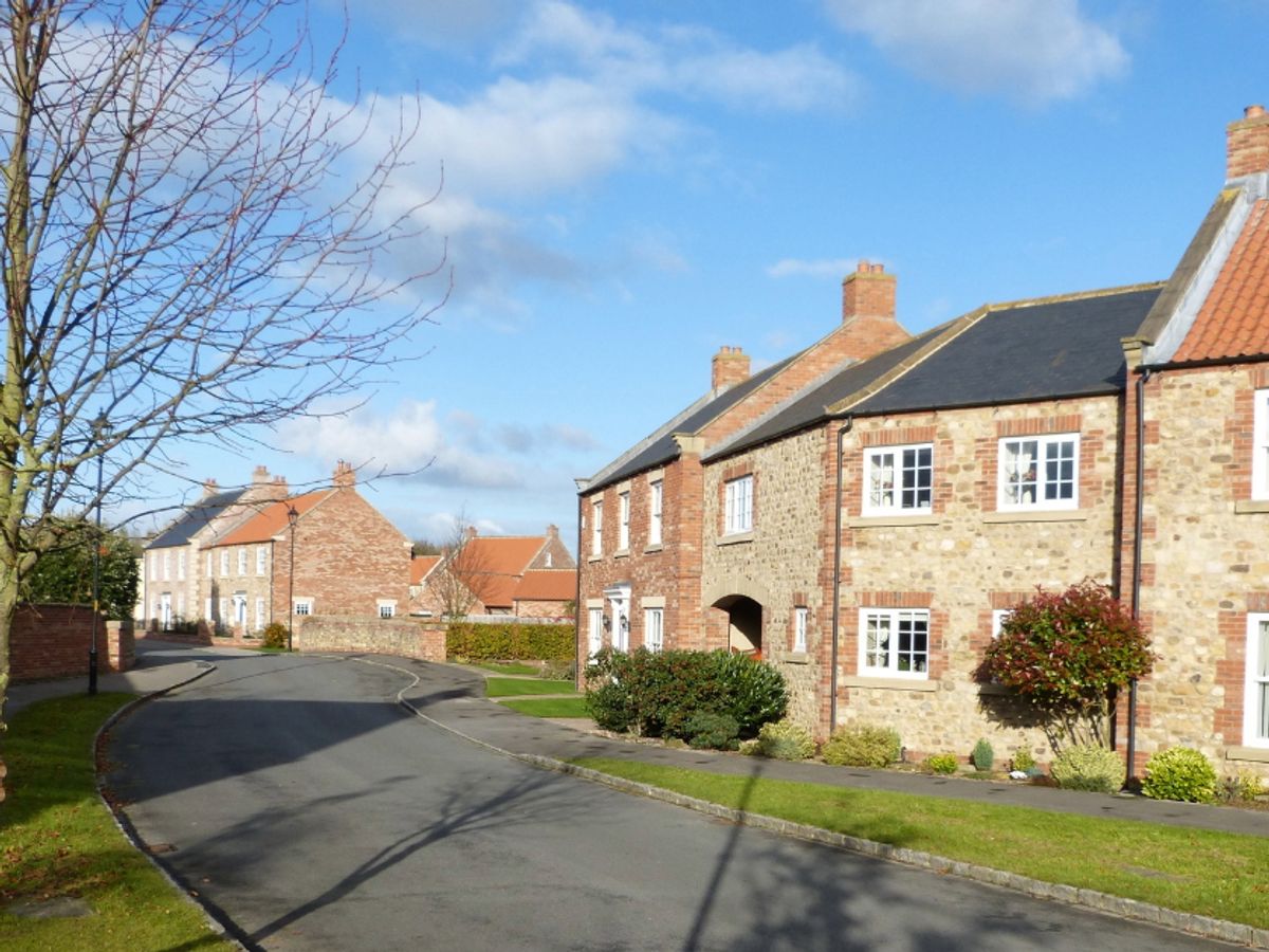 Road going through a village with new build houses