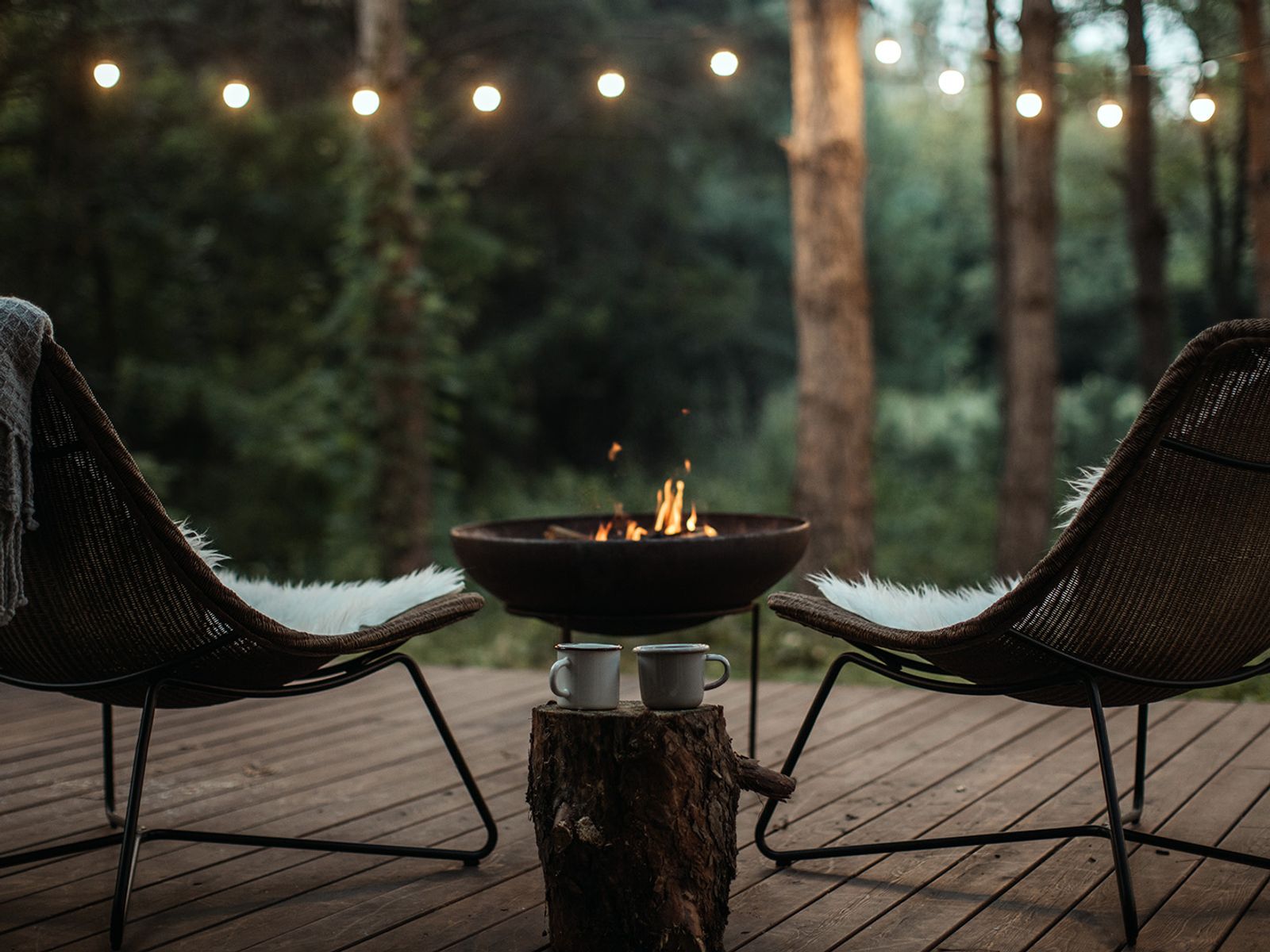 a pair of comfy seats neat to a campfire