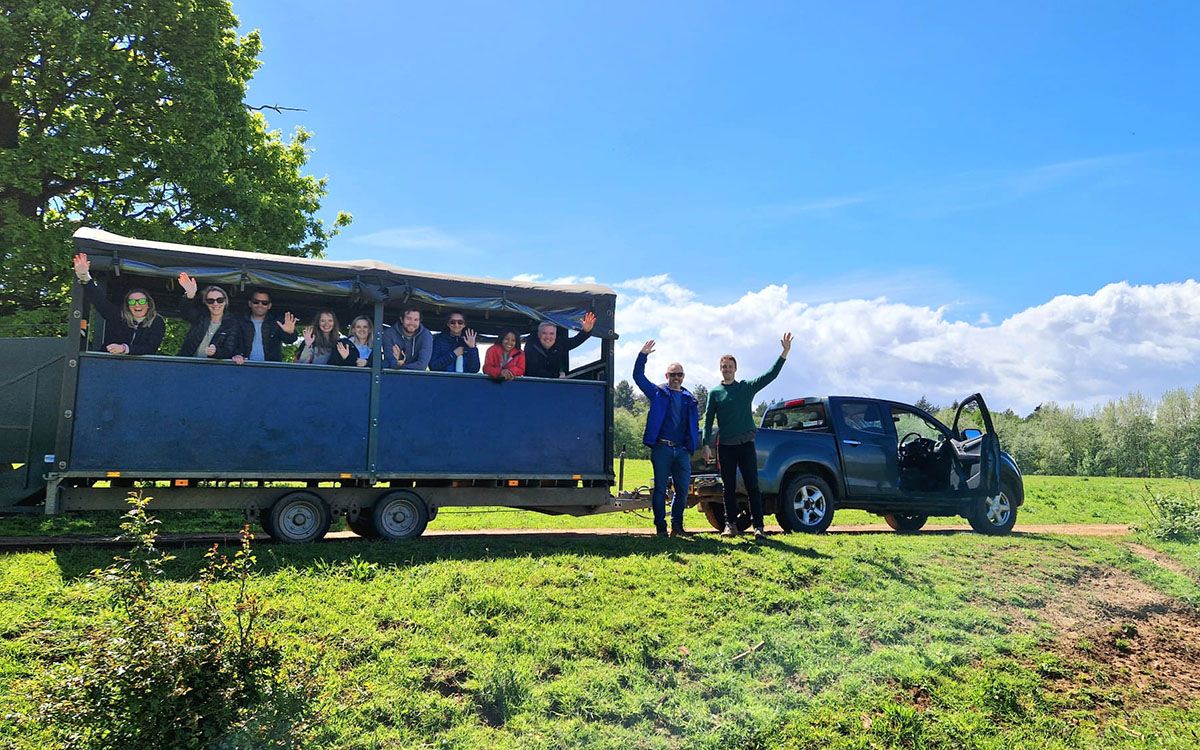 Photo of the RSL team on a day out at Wild Ken Hill. The team are in a trailer and are waving at the camera.