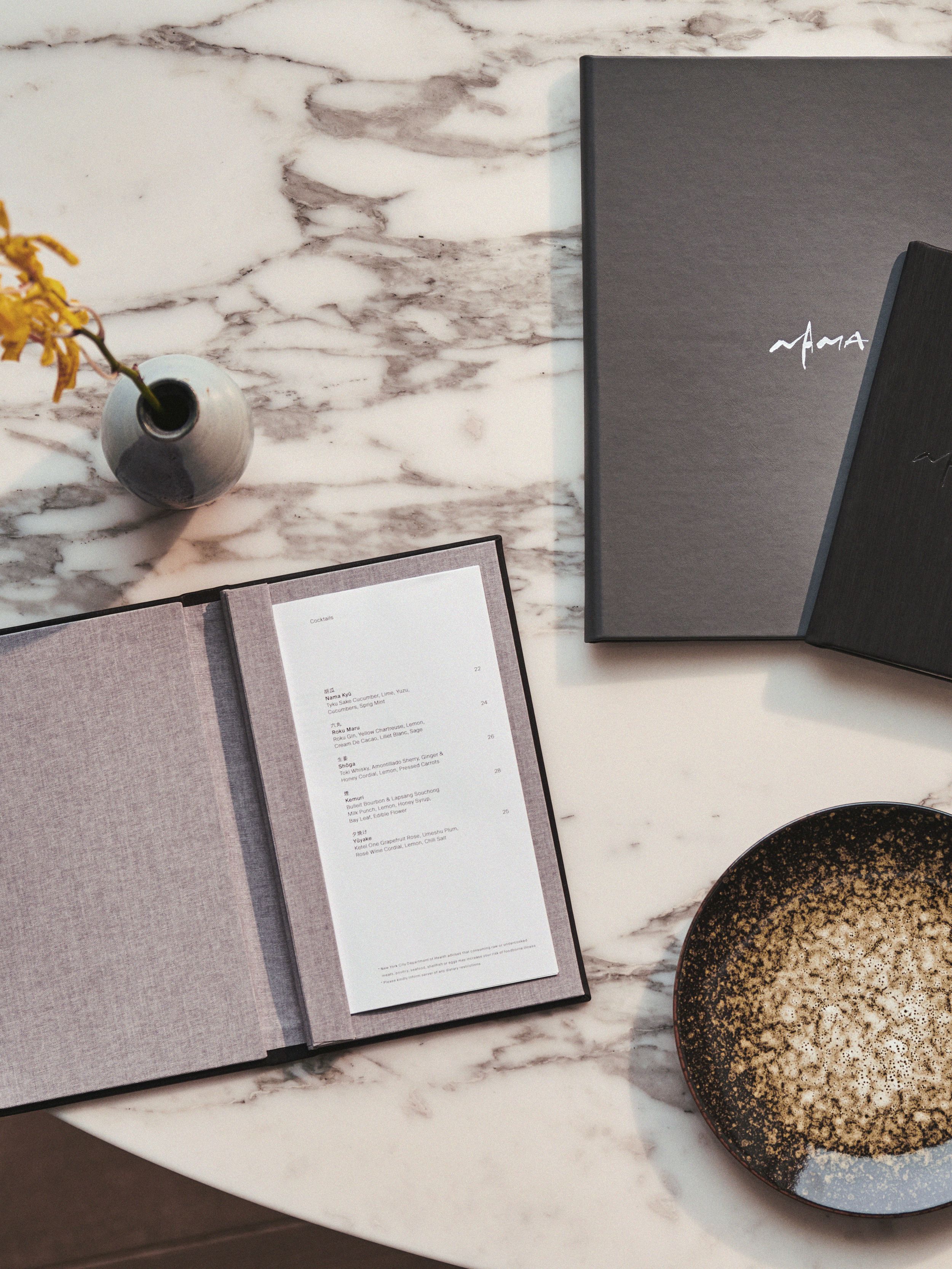 A luxury table setting featuring Nama food and drink menu designs by Colville-Walker. Produced by Identity Print in the UK.