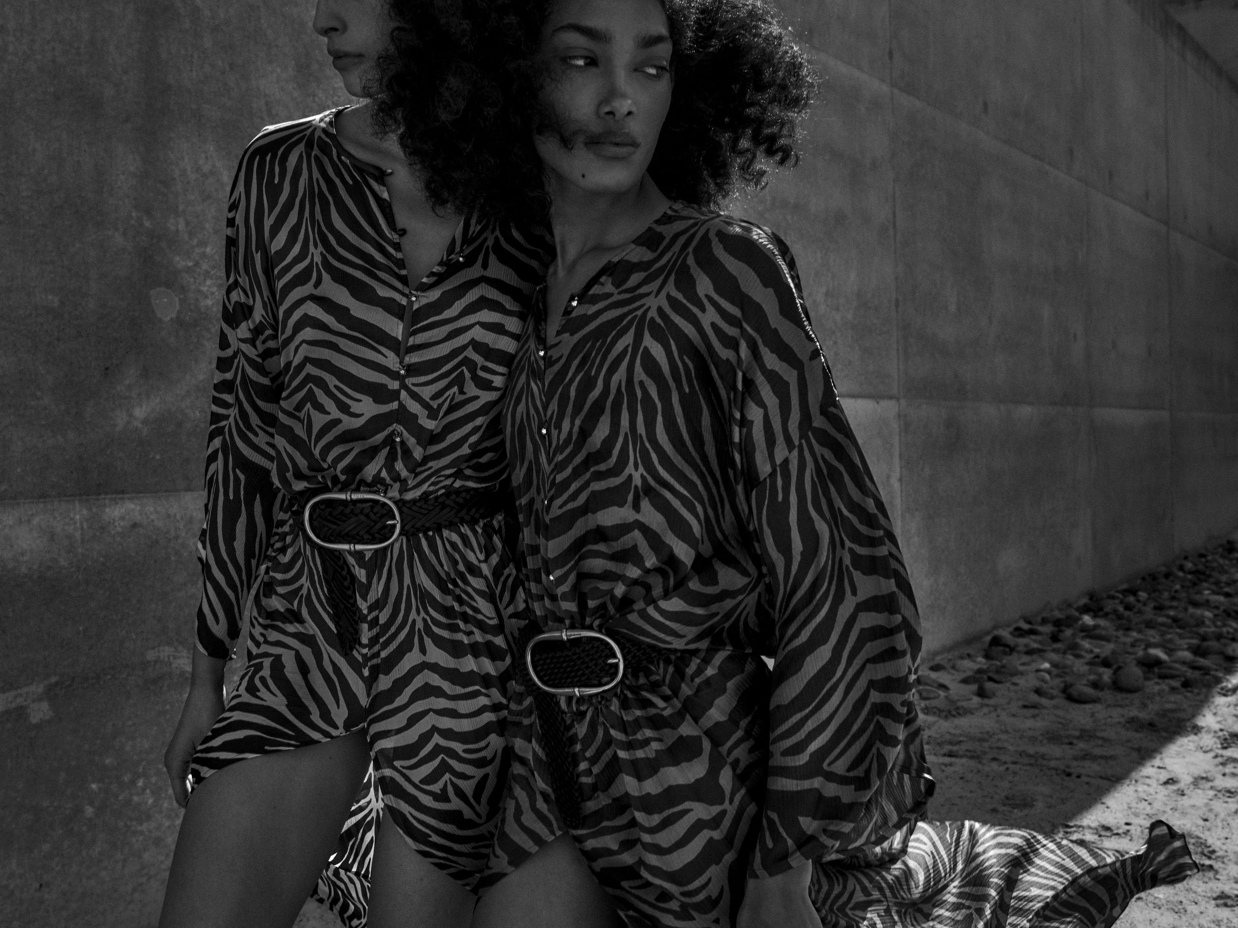 Two models gently walk along the outer walls of Amangiri, in the Utah desert. Photography by Chris Colls, Art Direction by Colville-Walker.