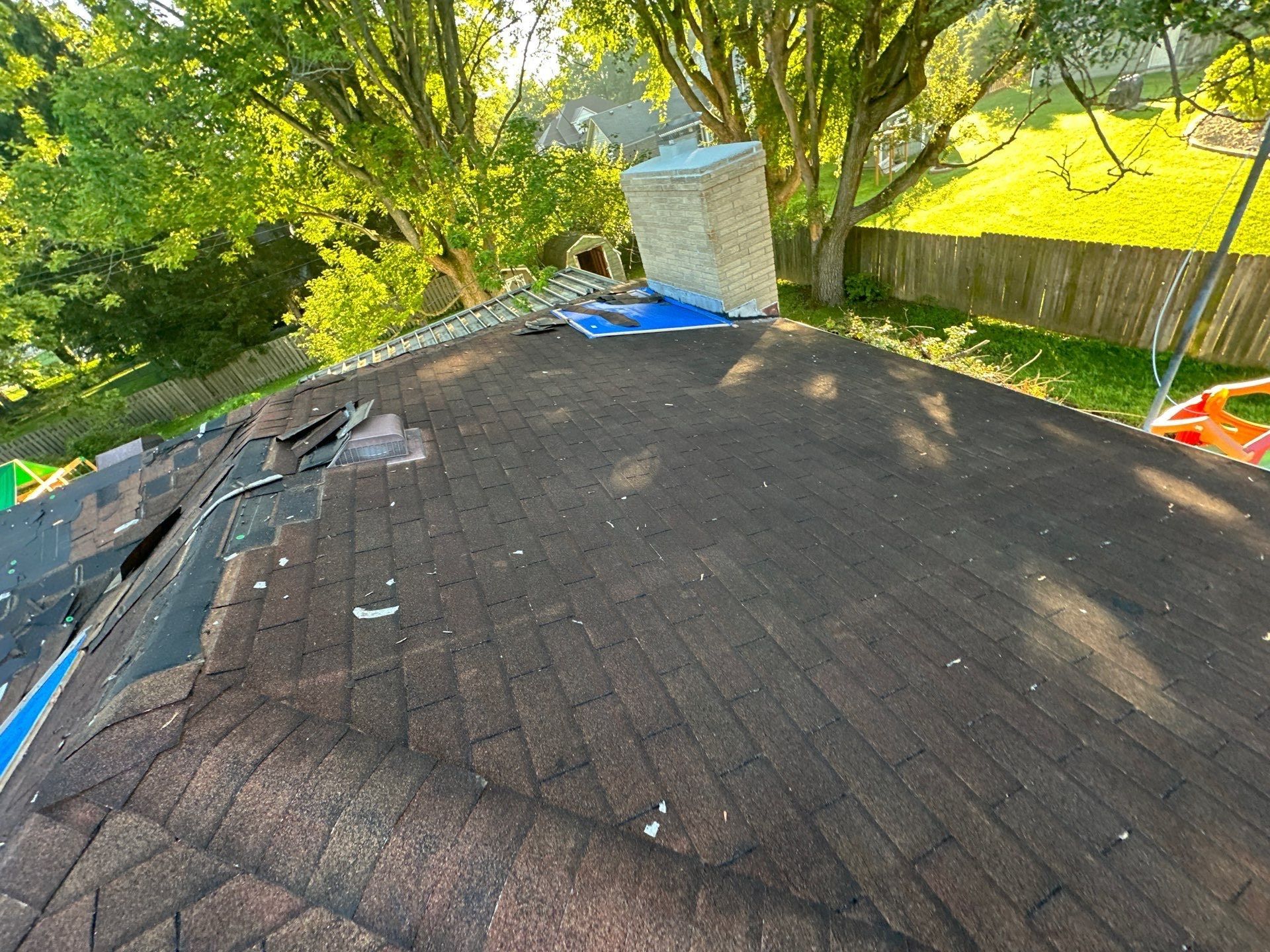 Old shingles partly stripped from the back hip slope on install day, Beavercreek, Ohio.