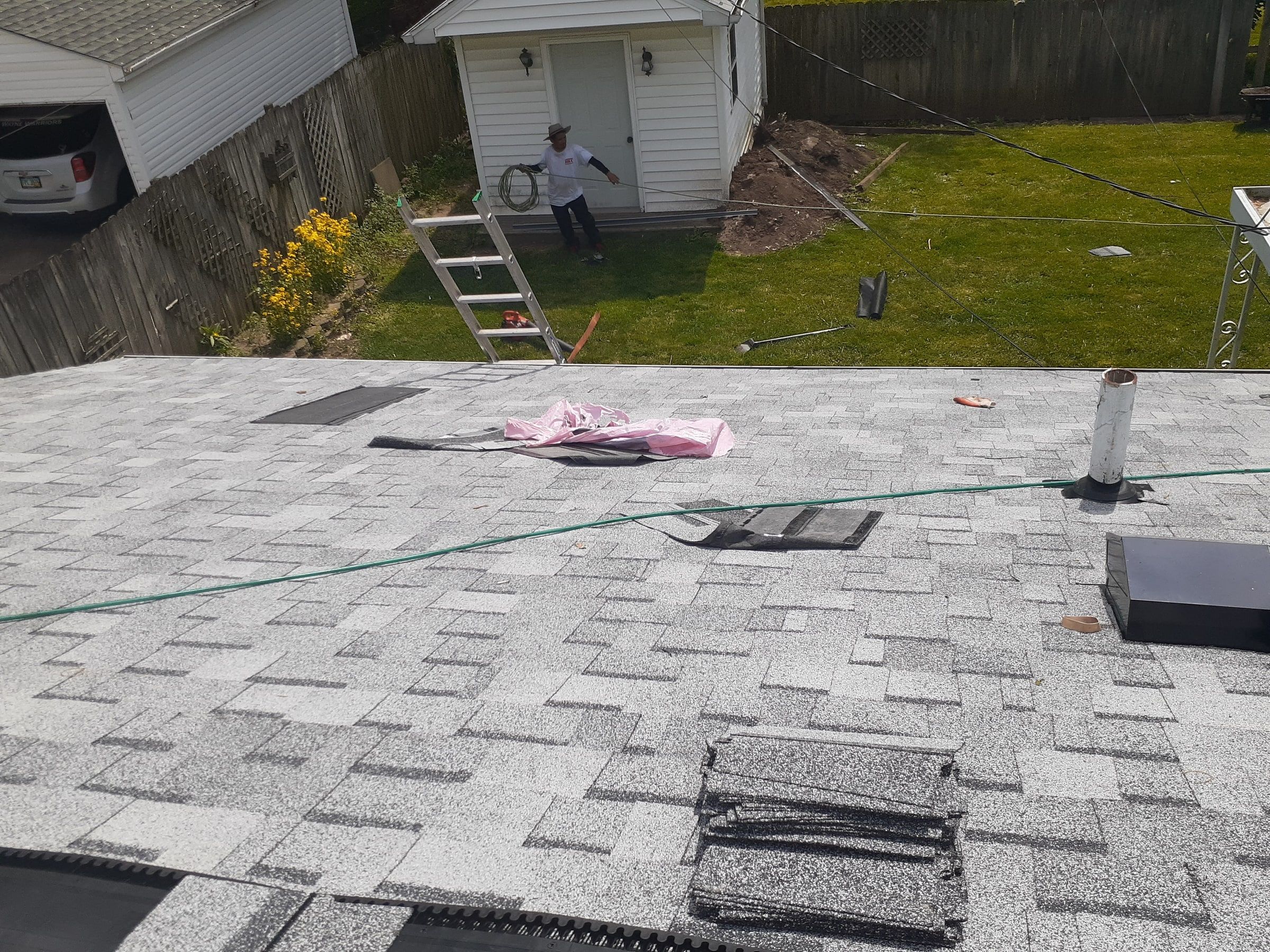 New shingles around a vent pipe, with the garage in the yard below, Huber Heights, Ohio.