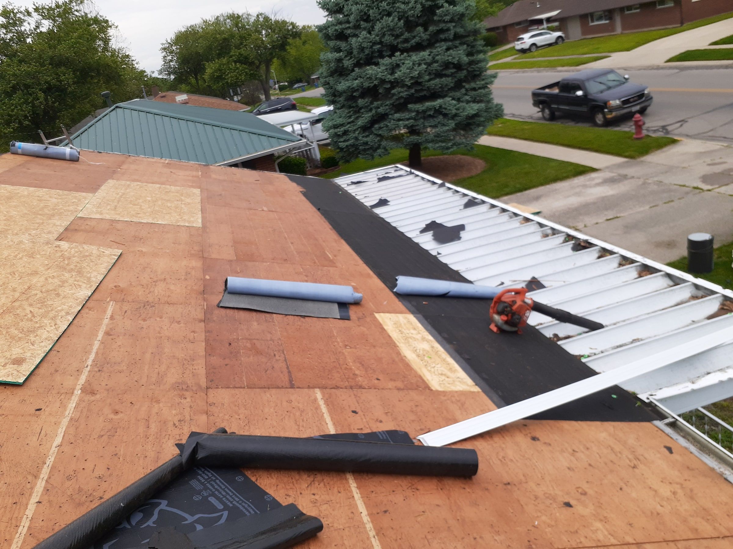 New OSB patches in the deck, with rolls of underlayment laid out, Huber Heights, Ohio.