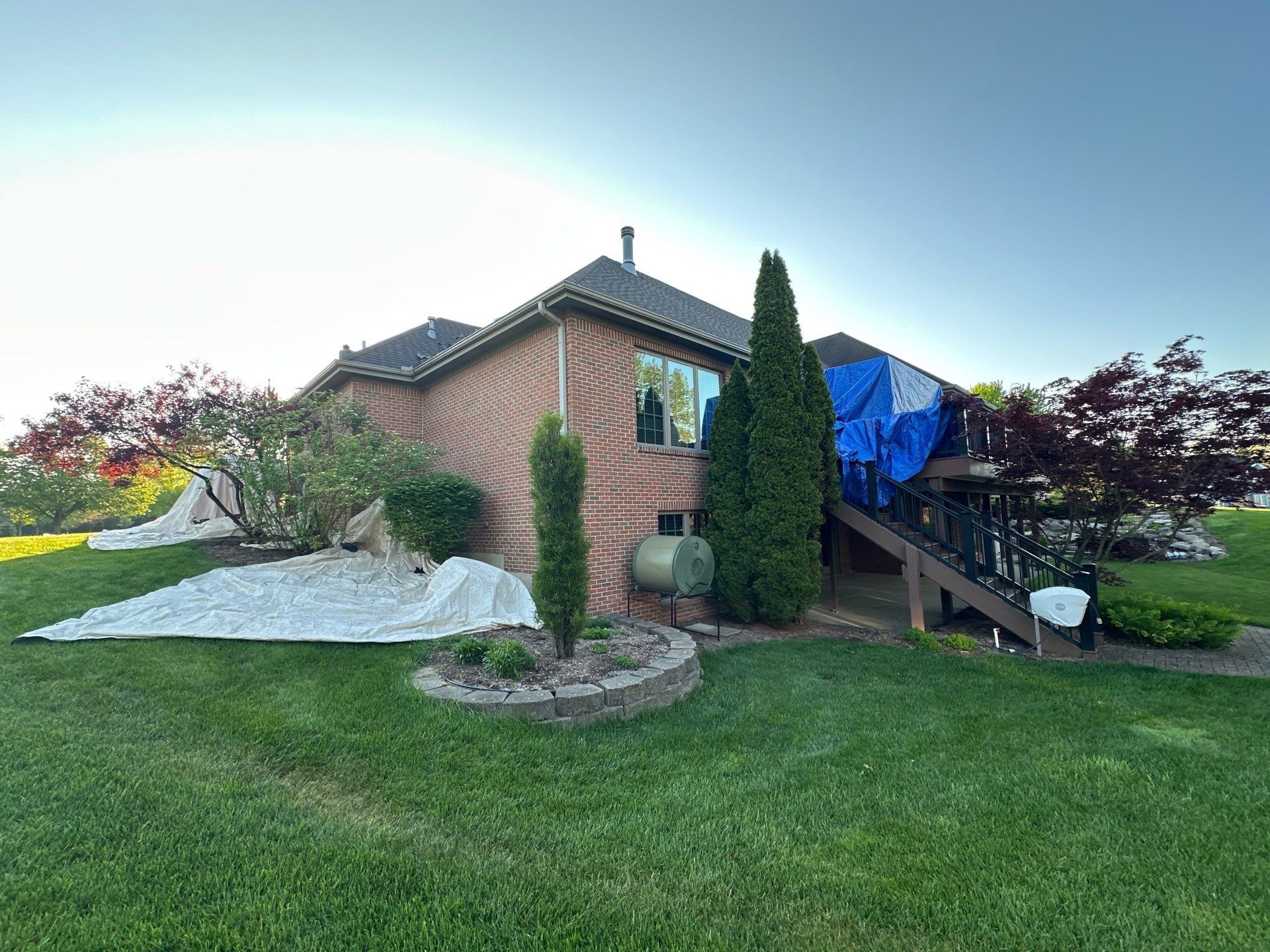 Tarps across the rear beds and lawn