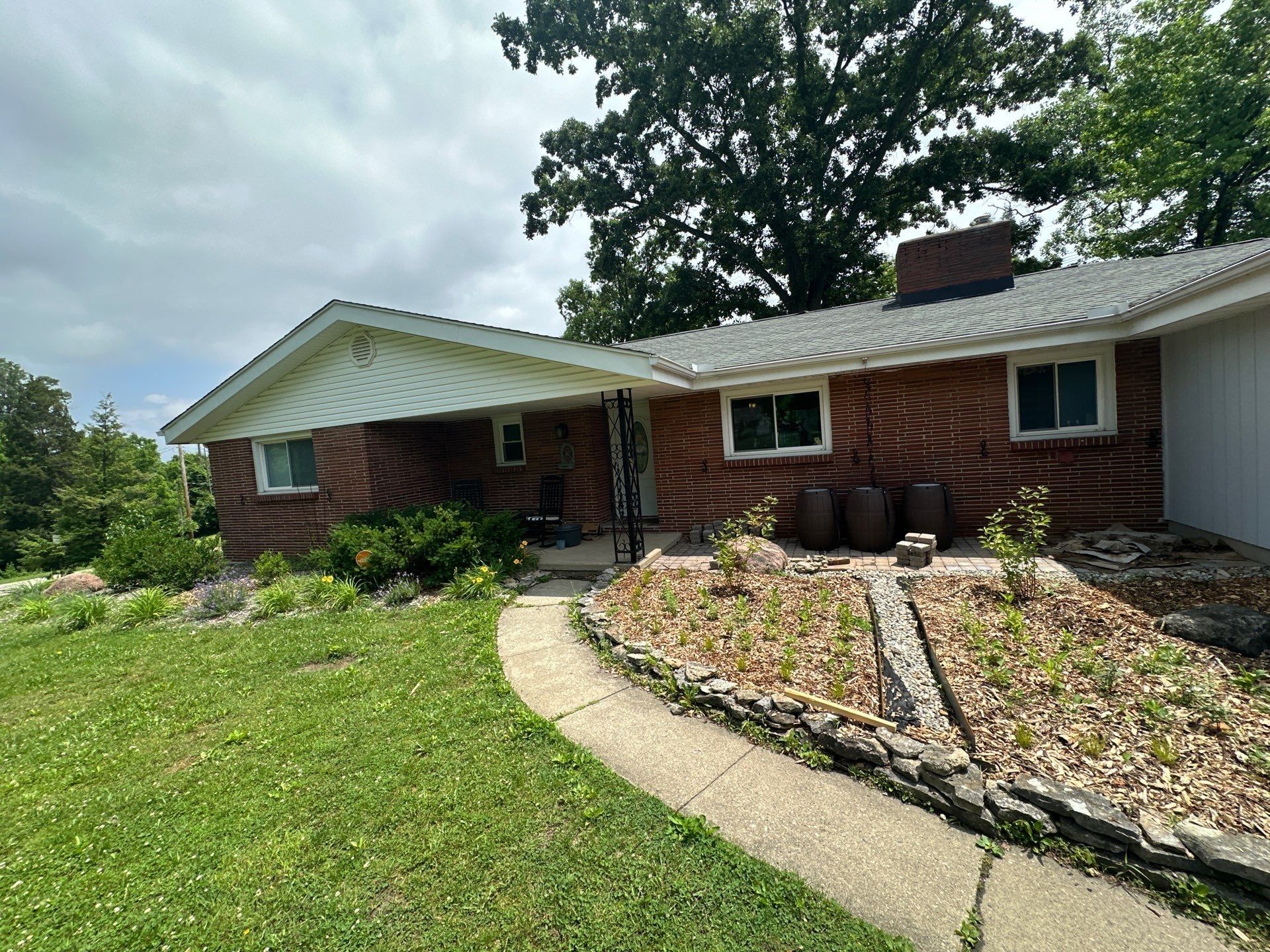 The covered front porch and the brick front of the ranch with the old gutters.