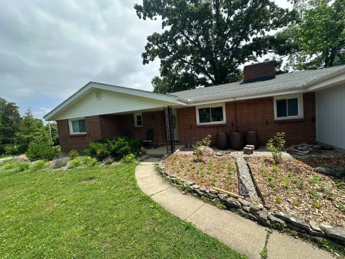 The covered front porch and the brick front of the ranch with the old gutters.