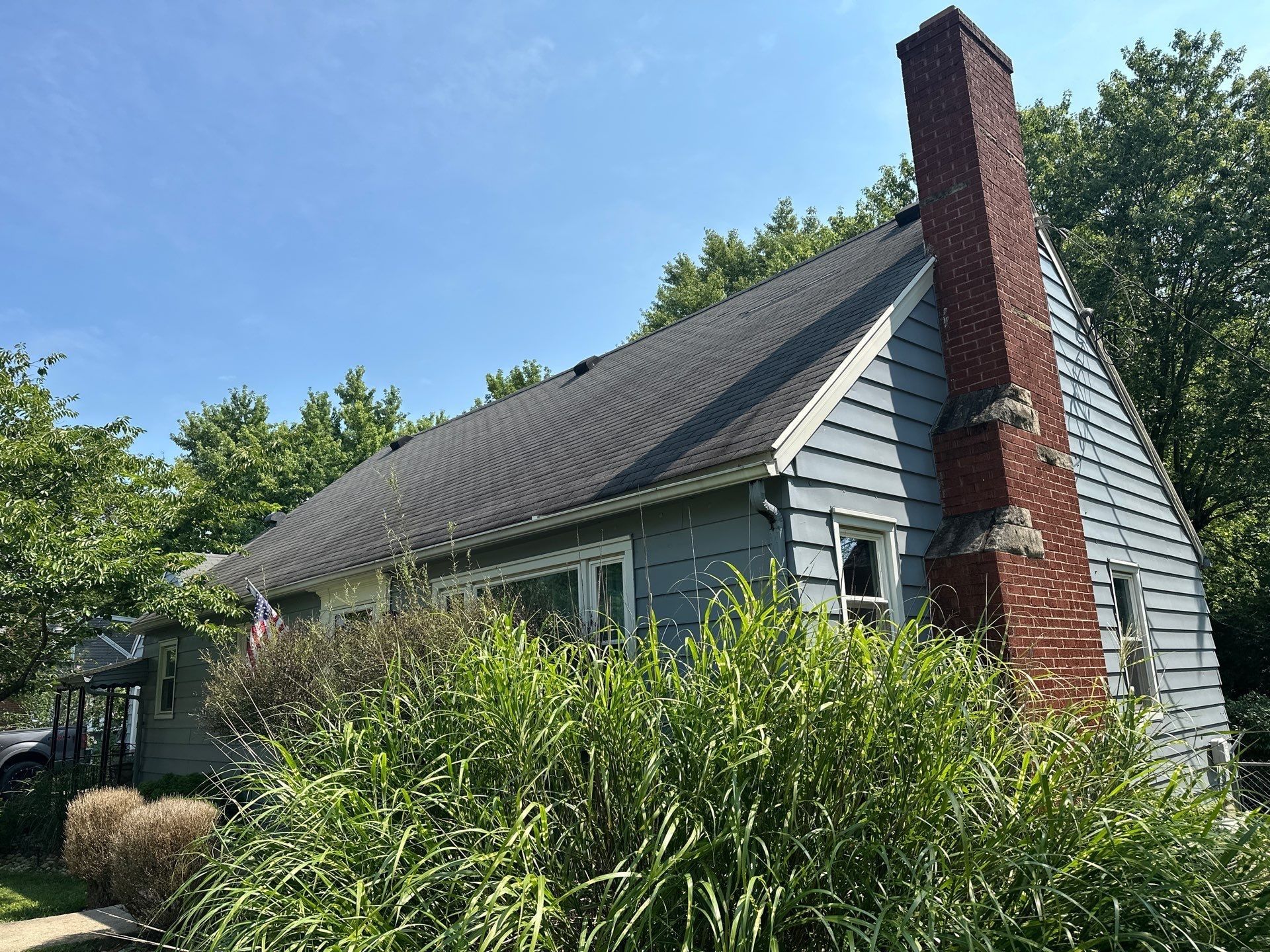 The brick chimney on the gable end, behind tall grasses, Beavercreek, Ohio.