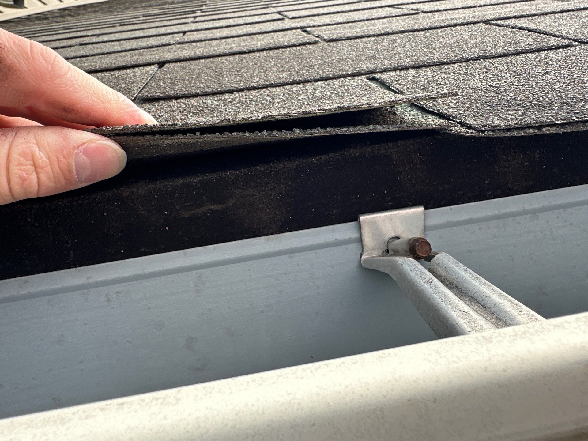 Hand lifting the shingle edge