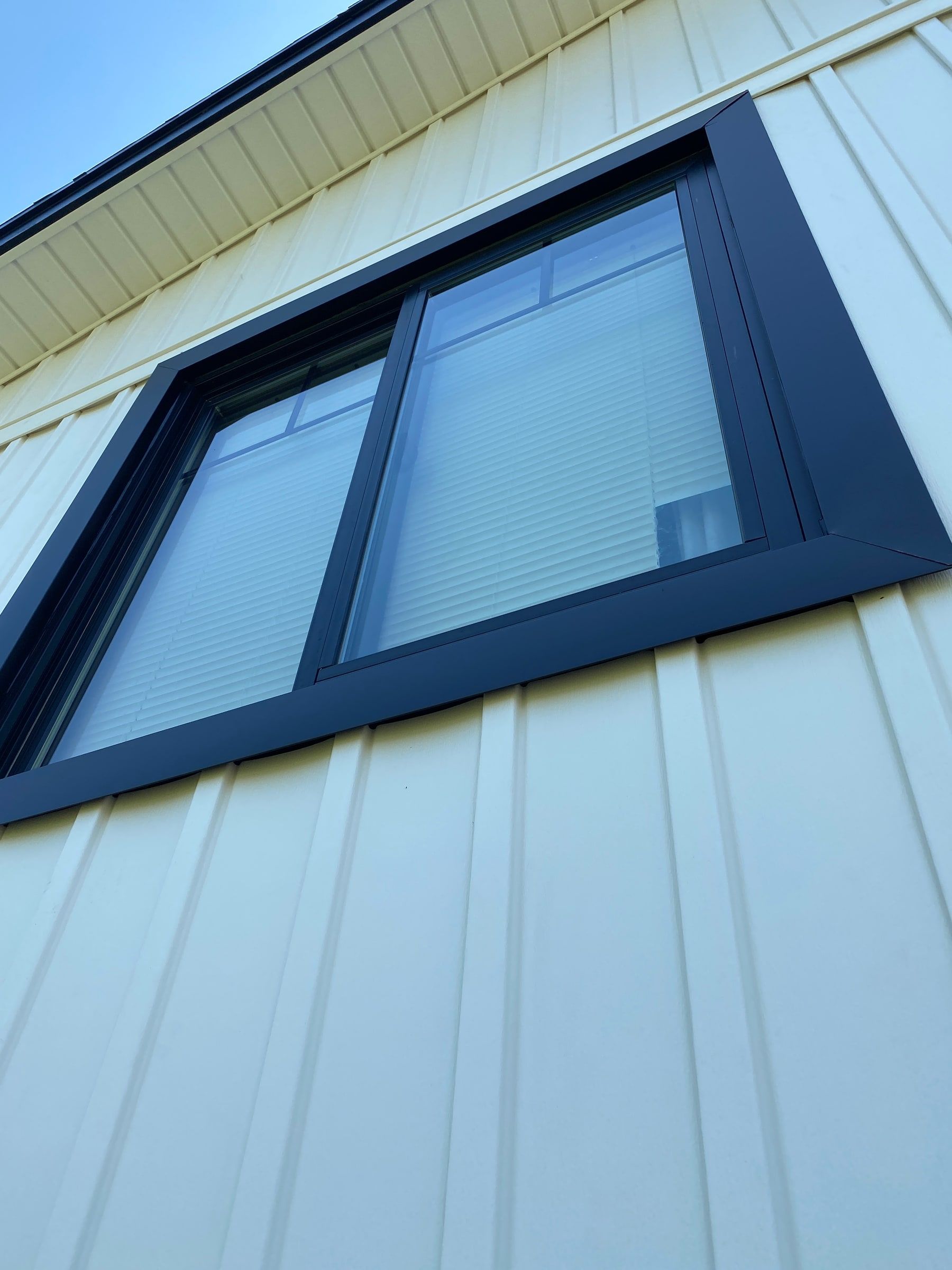New dark window trim against the white siding, close up, Beavercreek, Ohio.
