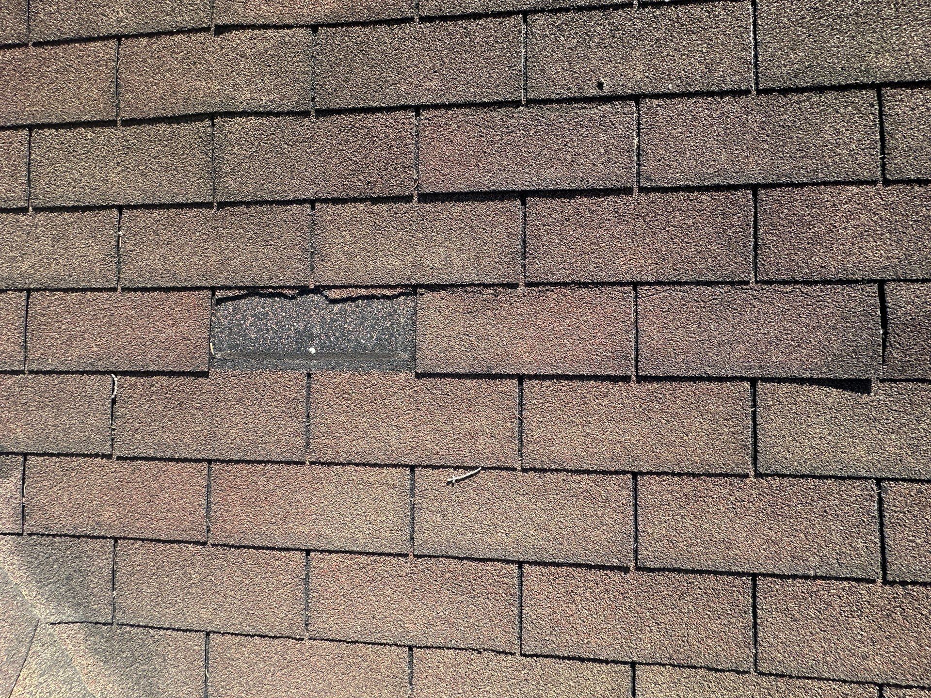 Missing shingle tab leaving a bare strip in the middle of the slope, Beavercreek, Ohio.