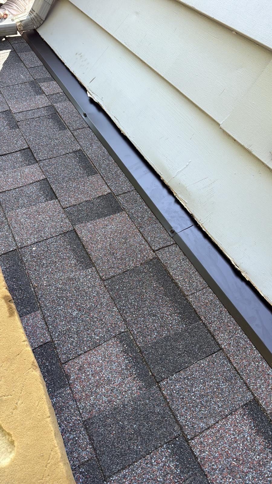 New shingles along the wall where a lower roof meets the siding, Beavercreek, Ohio.