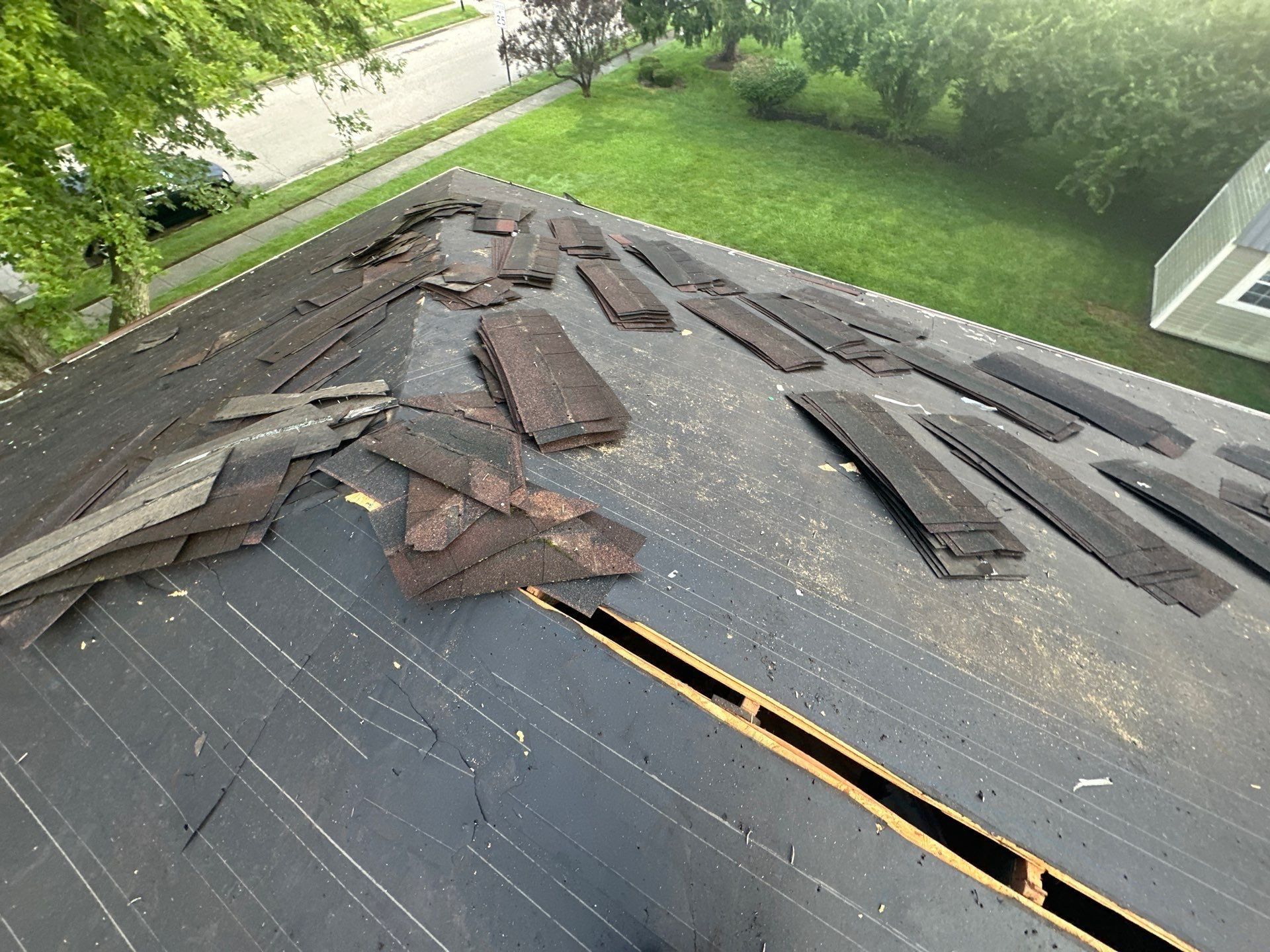 Stacks of torn-off shingles on the old underlayment, with the ridge cut open, Dayton, Ohio.