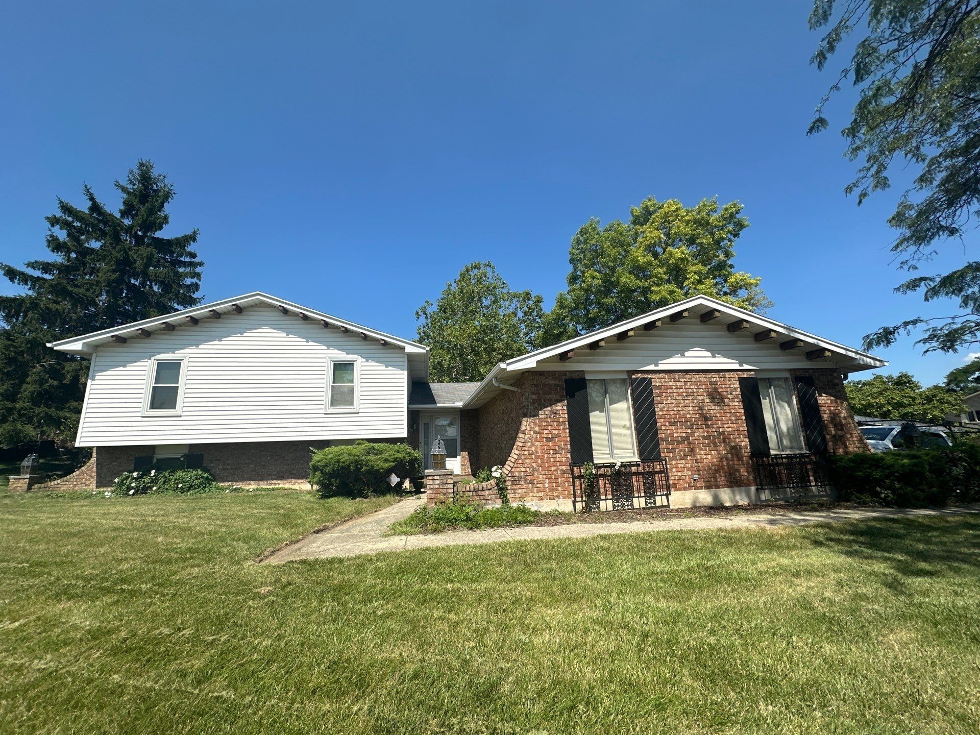 The split-level house and its brick wing from the front lawn, before the new roof, West Carrollton, Ohio.