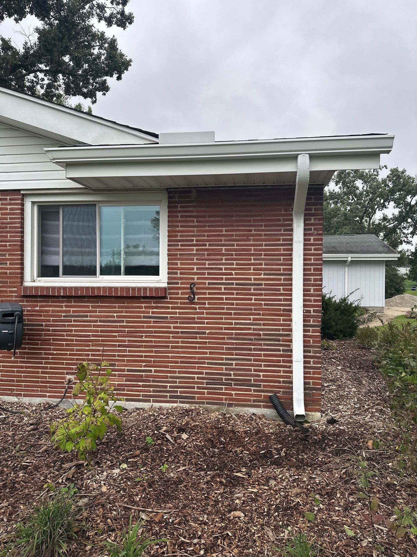 The new gutter and downspout along a brick side wall, West Carrollton, Ohio.