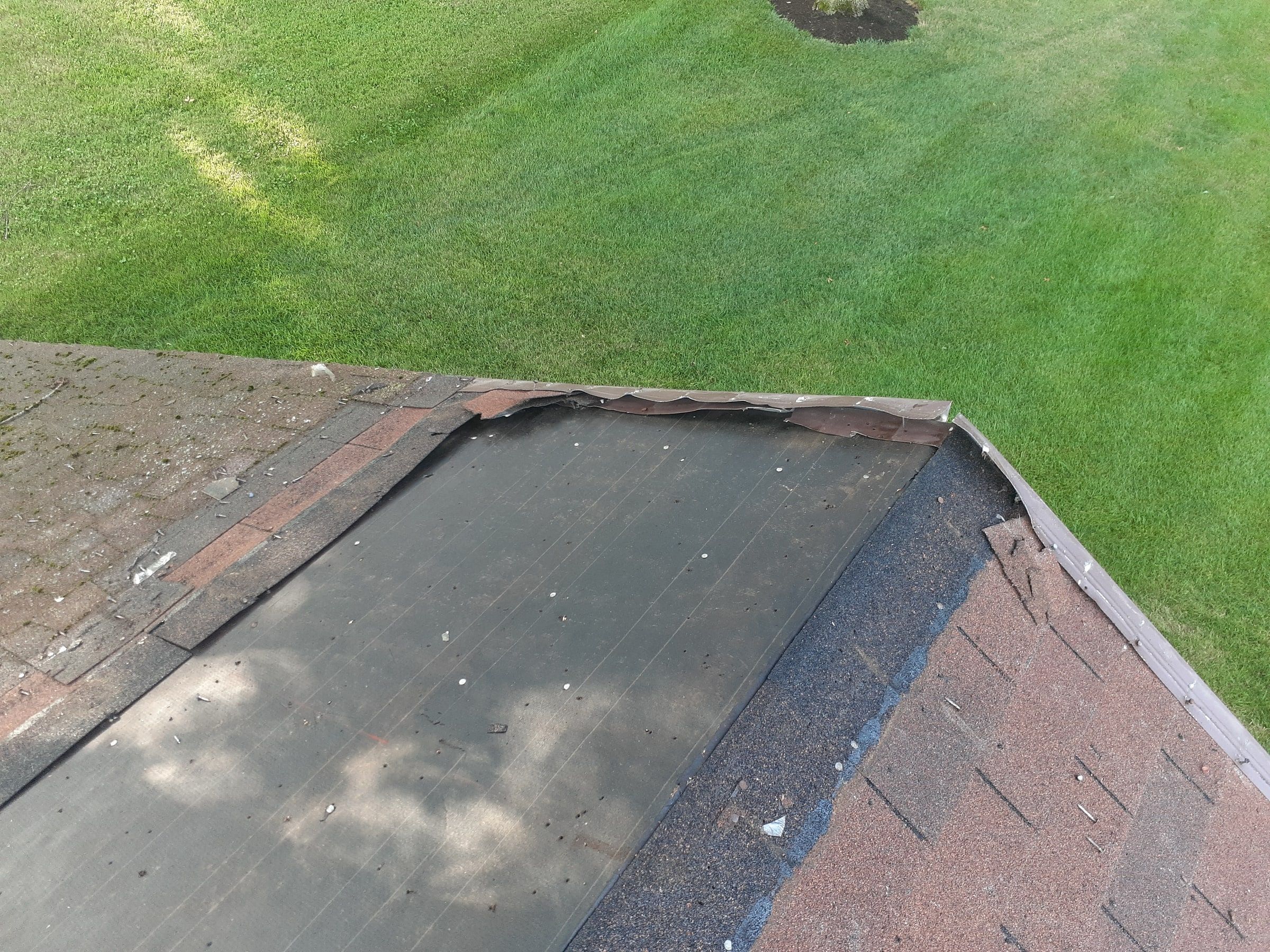 Old underlayment exposed along the eave after the shingles came off, Jamestown, Ohio.