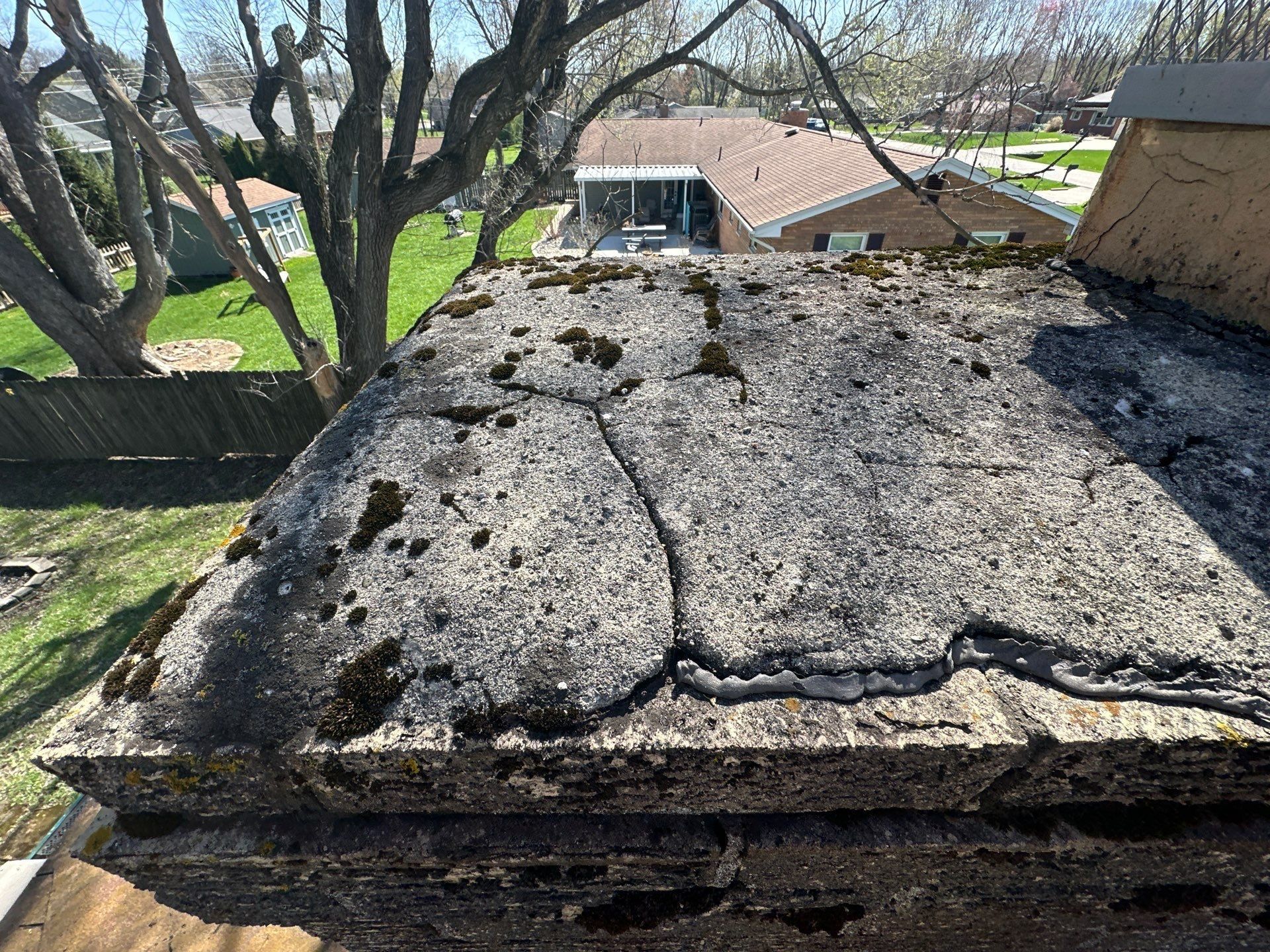 Cracked and moss covered chimney crown found during the roof inspection, Beavercreek, Ohio.