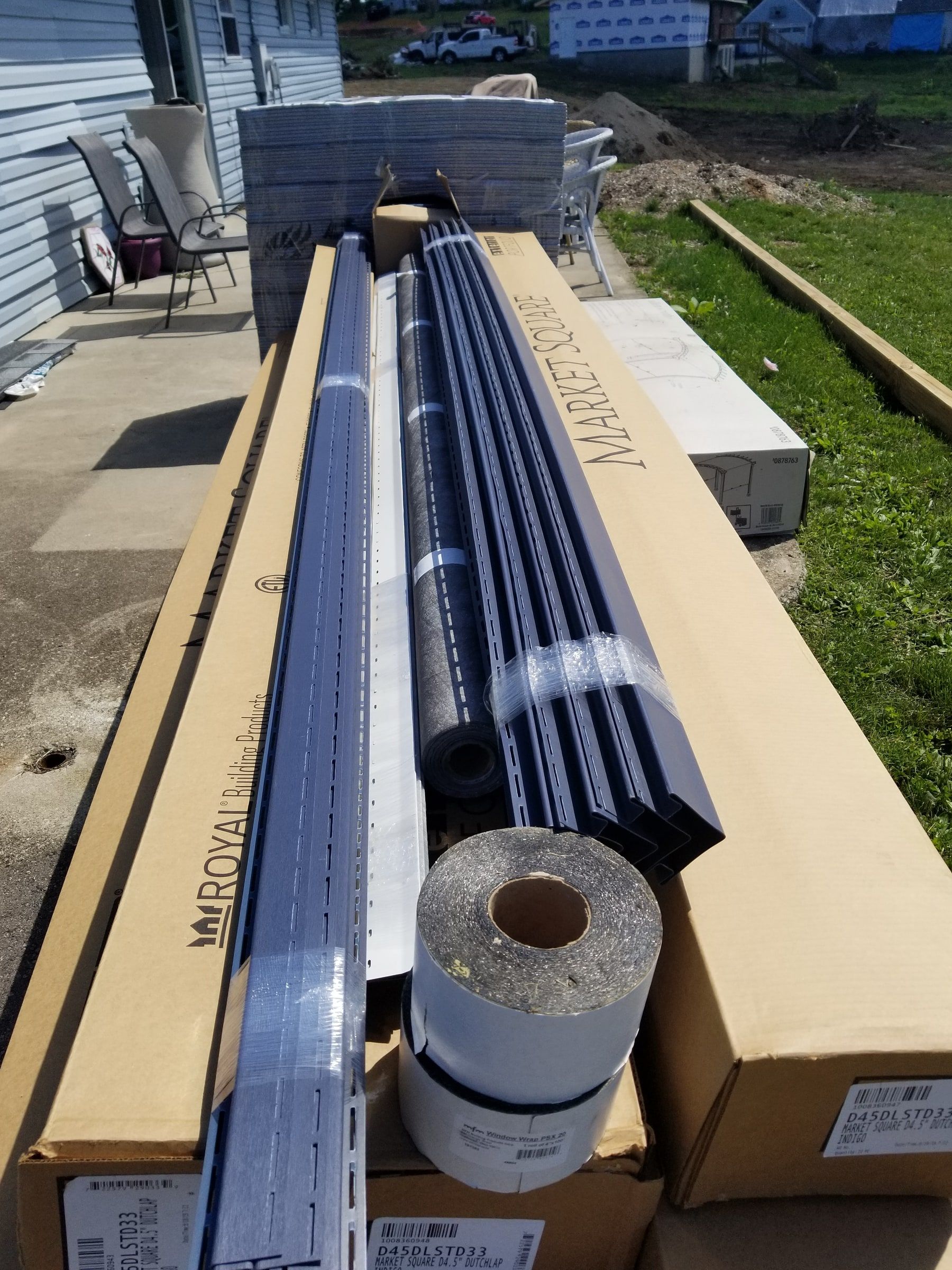 New siding, trim and roll stock stacked on the patio, Beavercreek, Ohio.