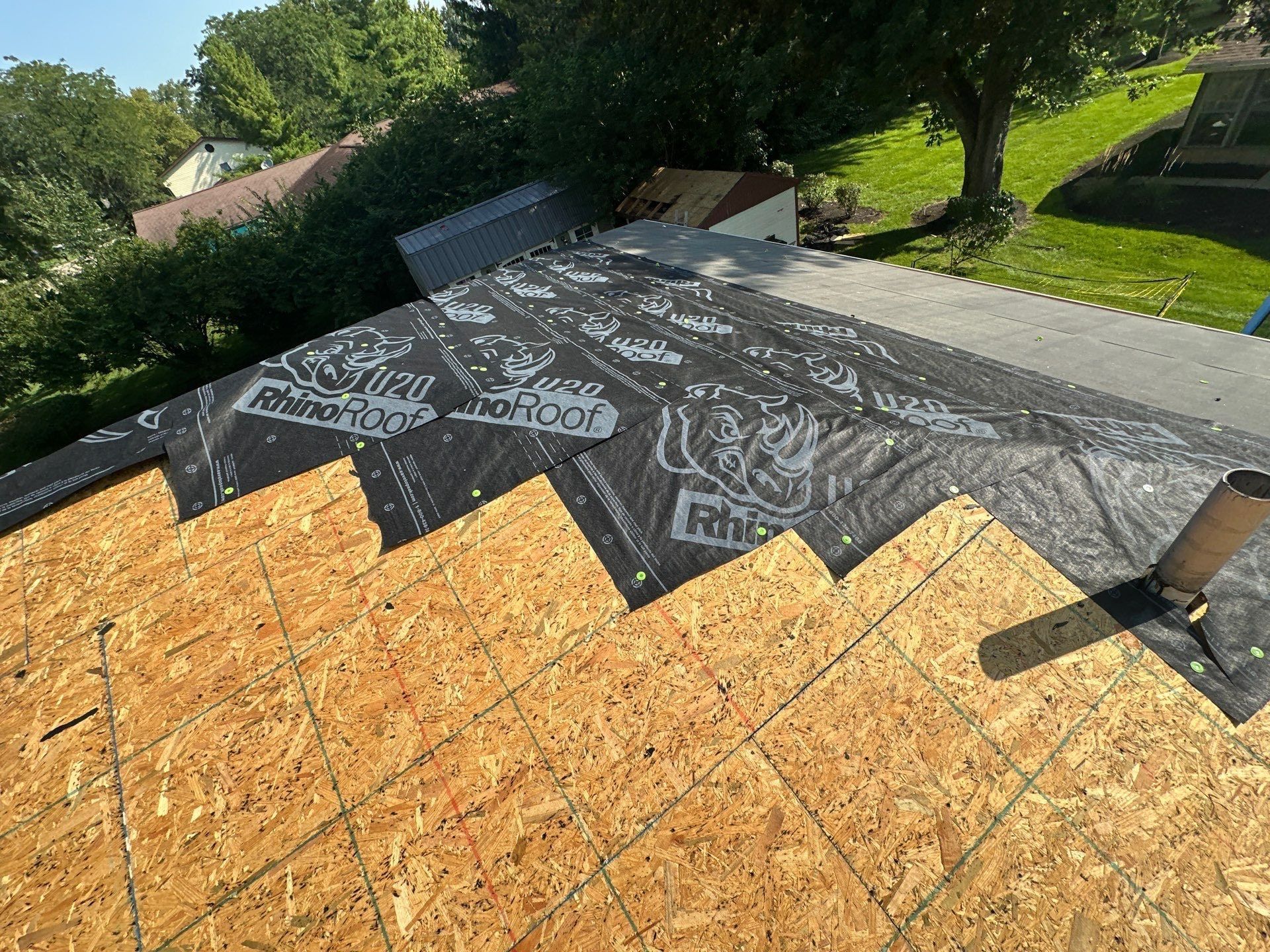 Synthetic underlayment starting up the clean deck around a vent pipe, Dayton, Ohio.