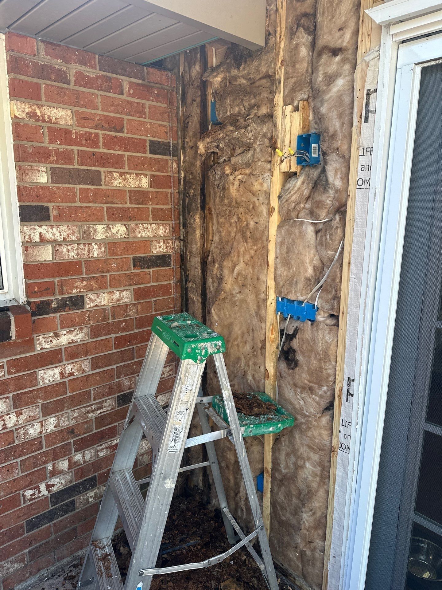 The opened wall beside the door, with insulation and electrical boxes, Beavercreek, Ohio.