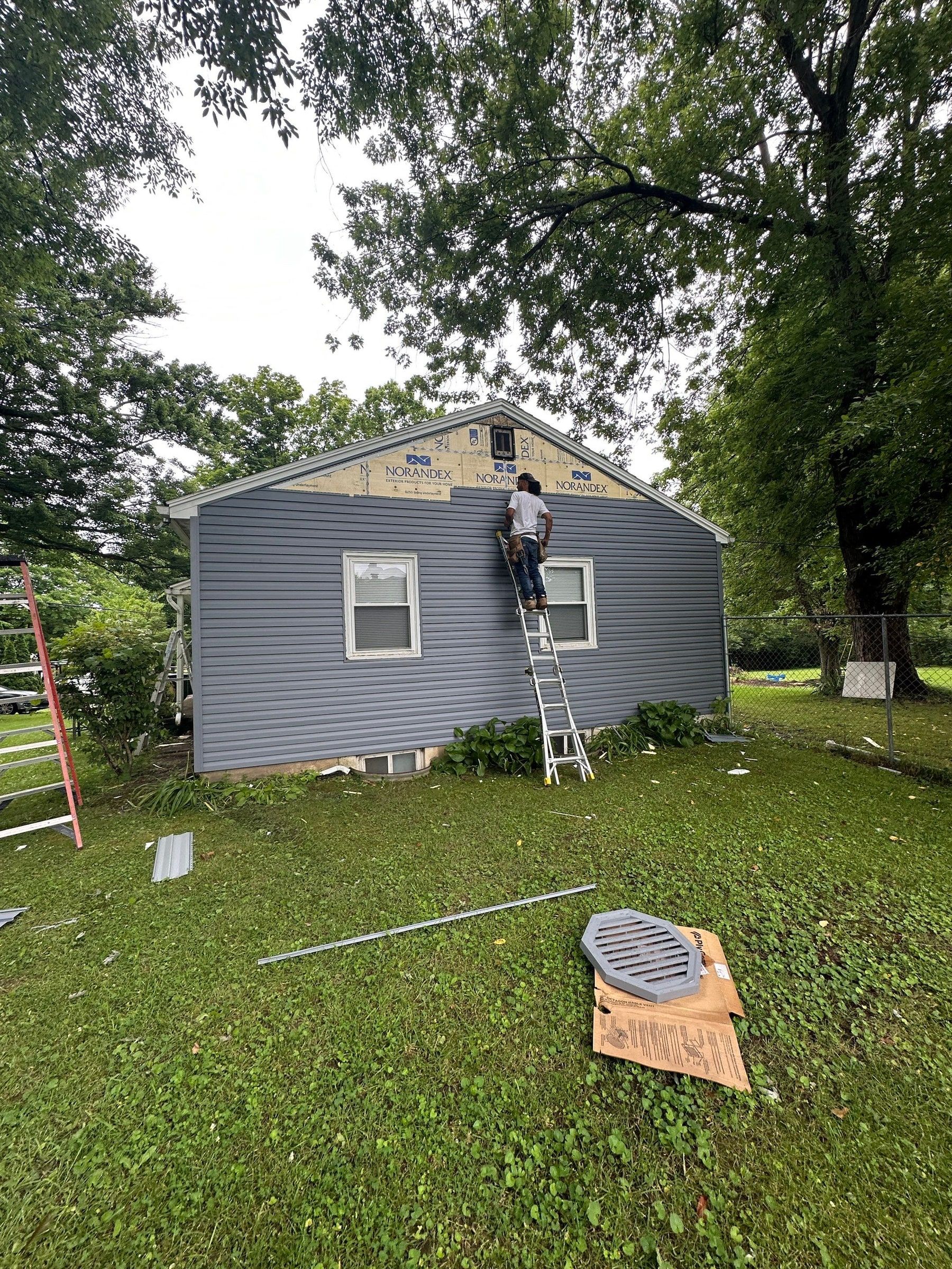 Siding going up on the gable end from a ladder, Beavercreek, Ohio.