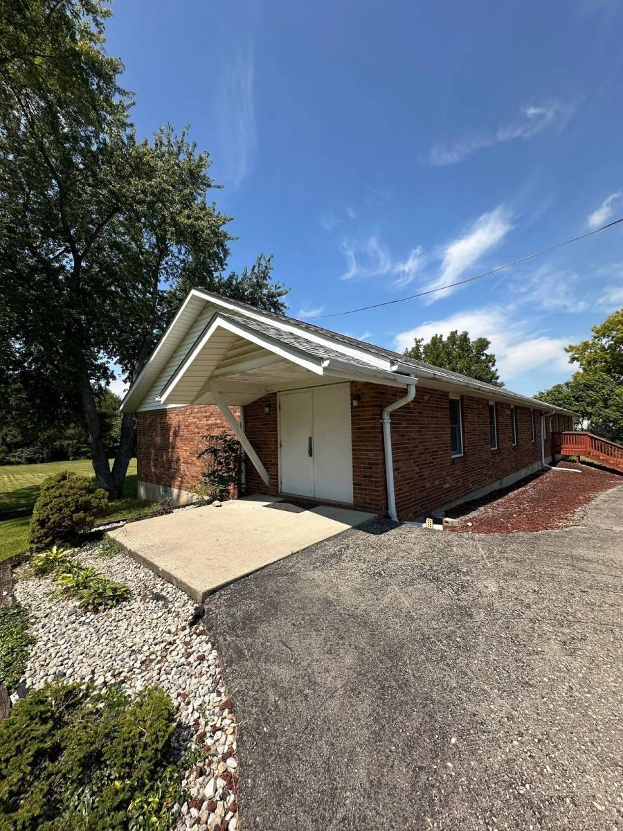 Church entrance and gable canopy under an asphalt shingle roof.