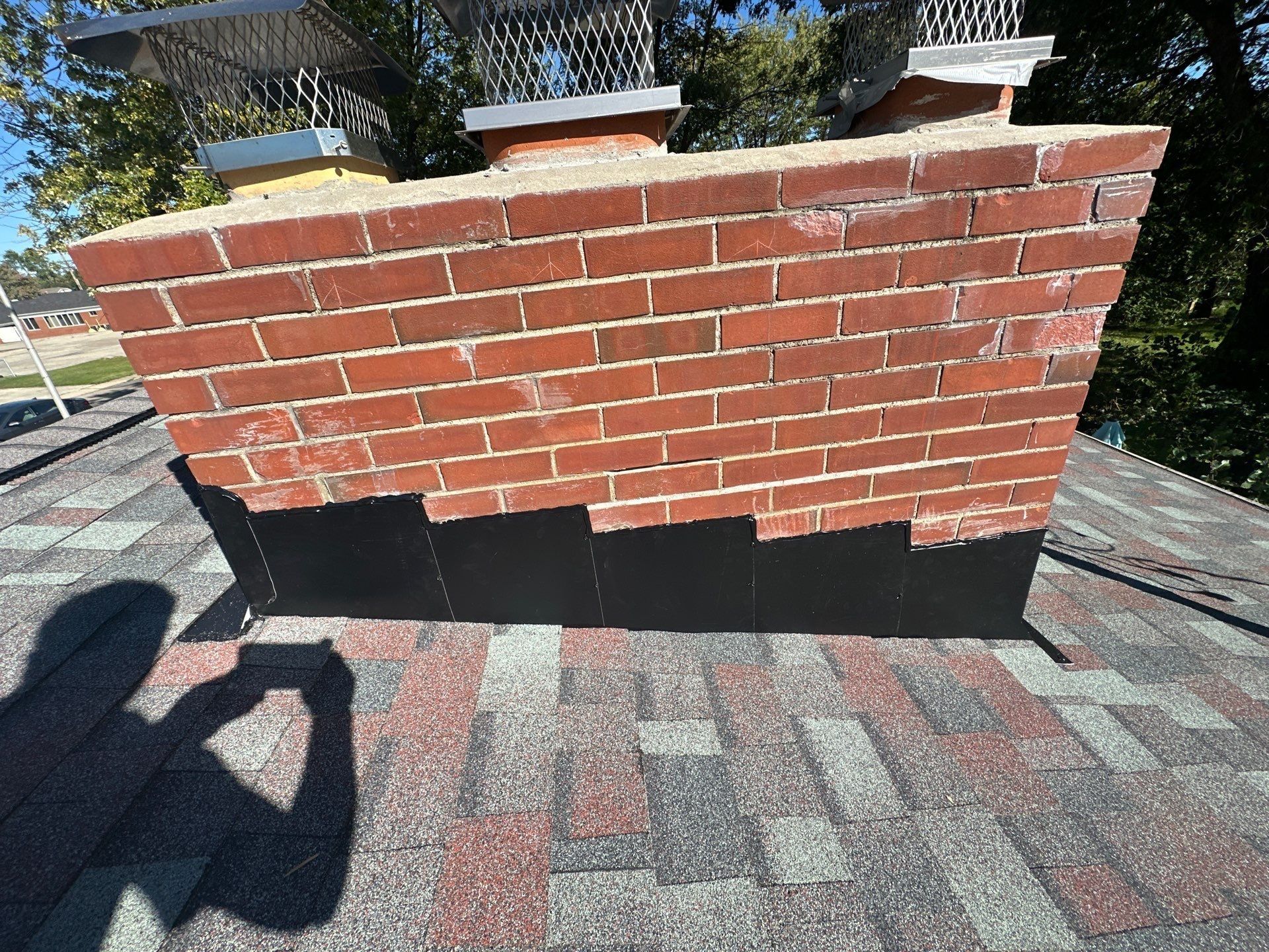 New black flashing stepped along the side of the brick chimney, Kettering, Ohio.