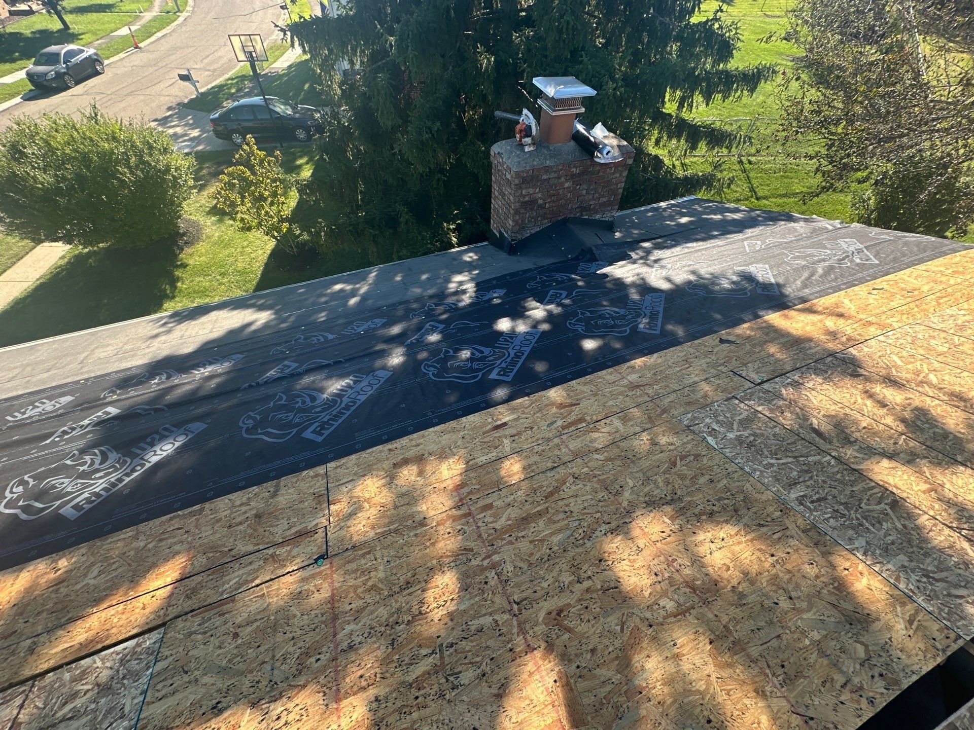New OSB on the deck beside the chimney, with underlayment starting, West Carrollton, Ohio.