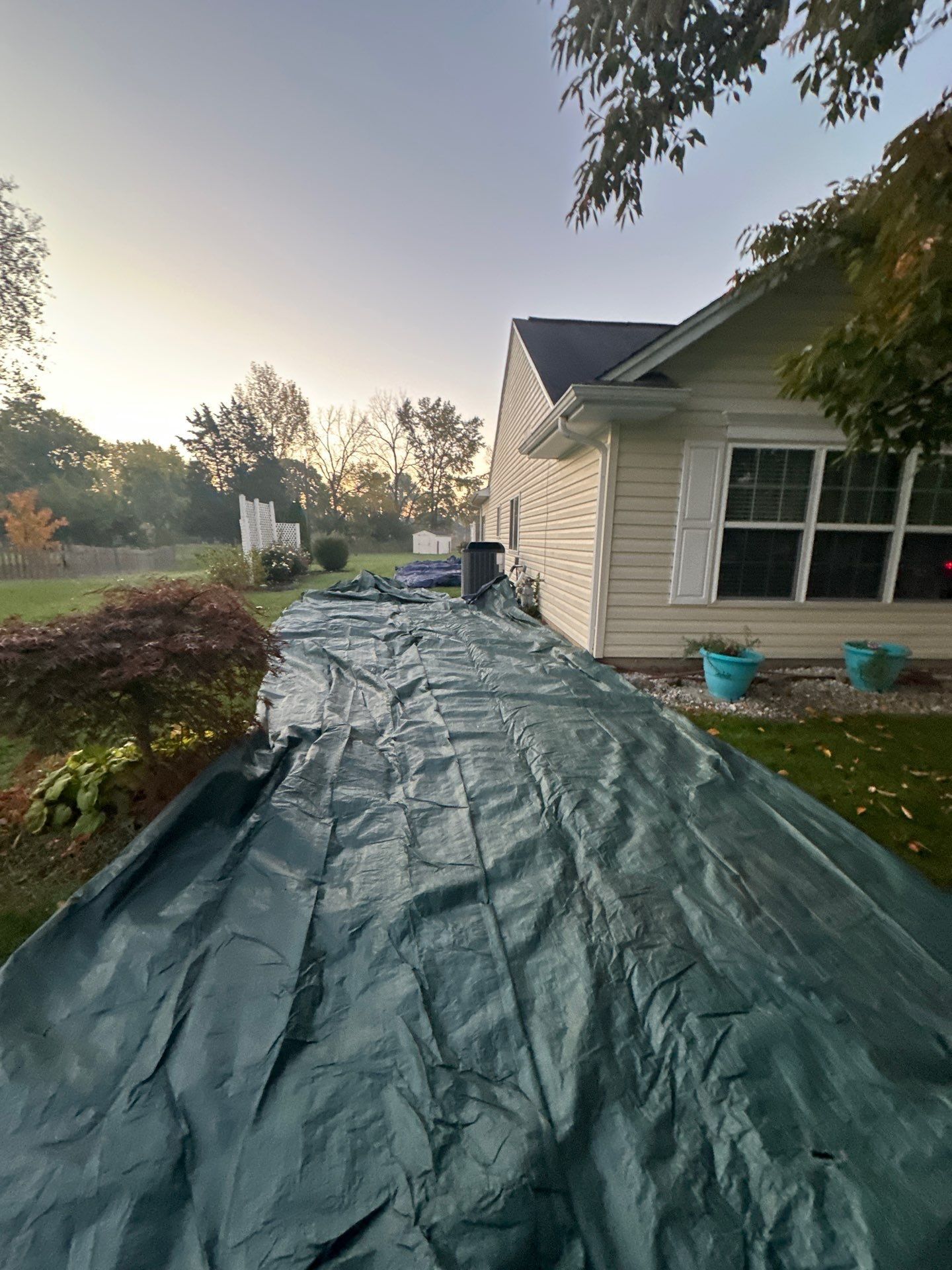A green tarp down the side yard along the house, Beavercreek, Ohio.