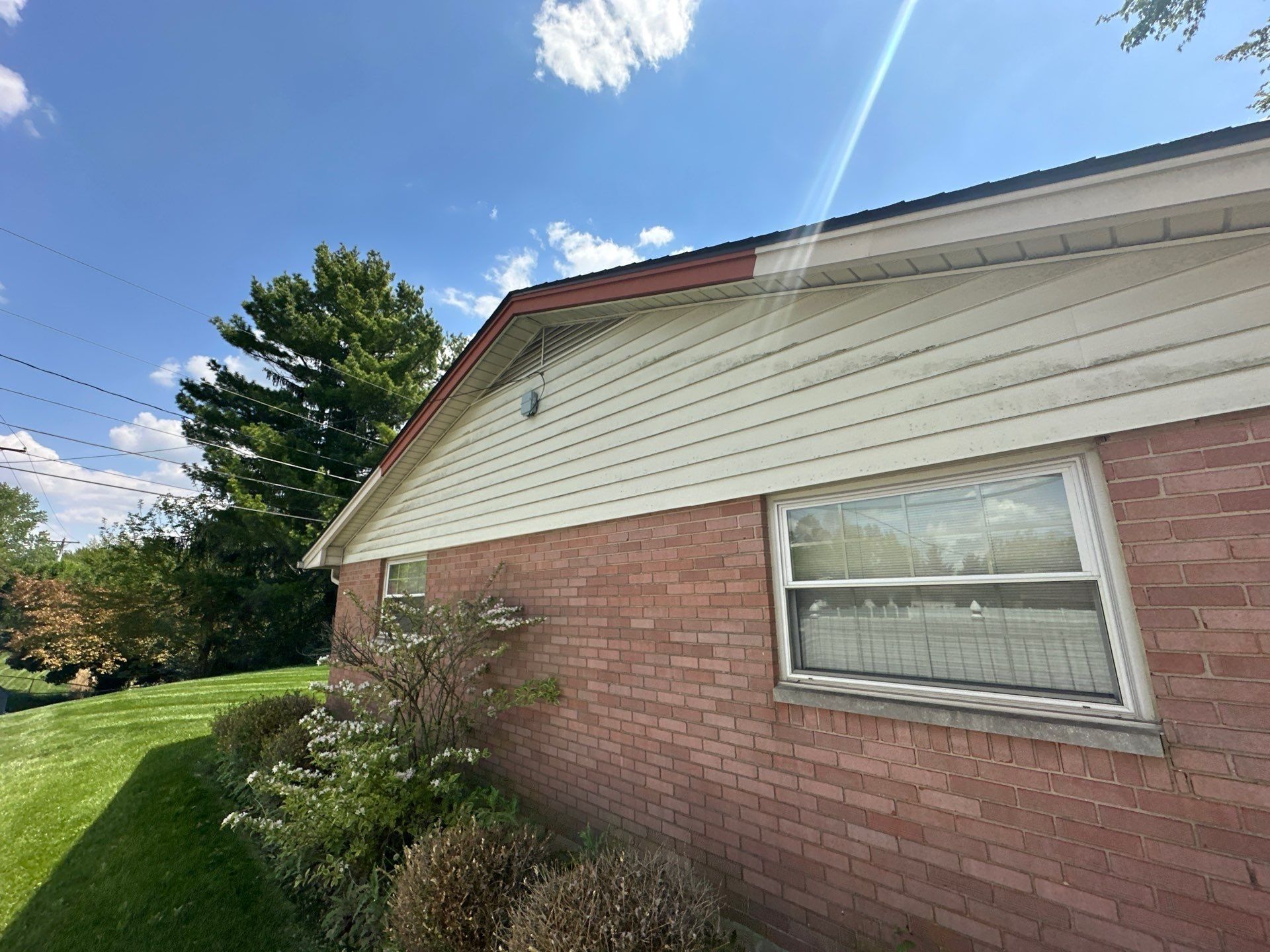 Wind-torn fascia on a gable, with the bare wood showing, Kettering, Ohio.